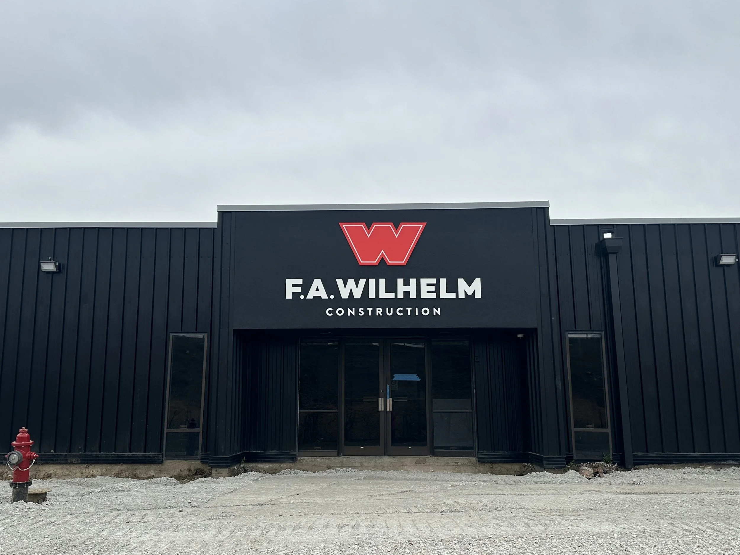 Front view of a black building with a sign reading 'F.A. Wilhem Construction' and a large red 'W' logo above the sign.