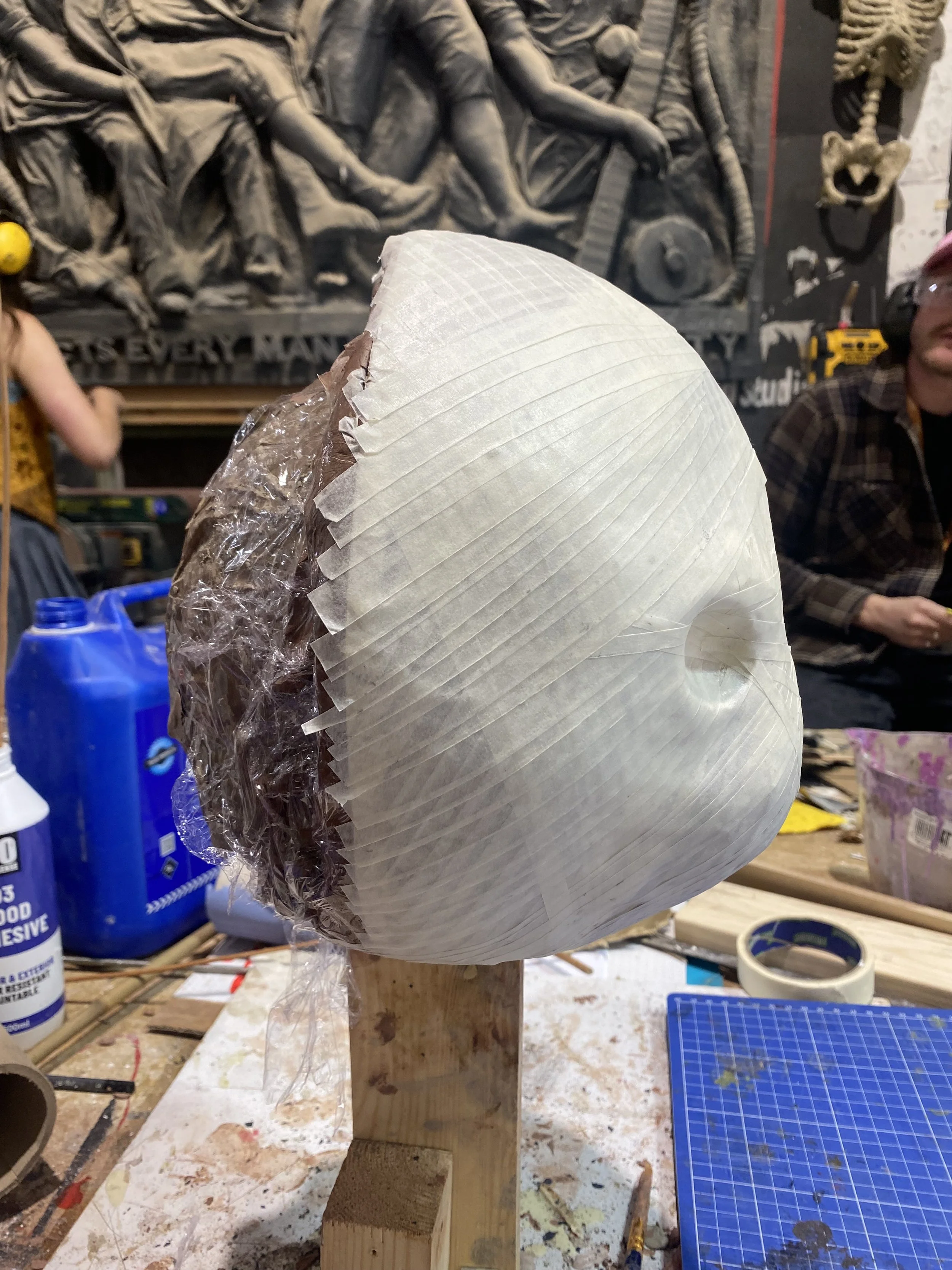 Covered sculpt in cling film and strips of masking tape.