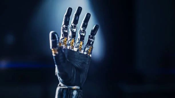 A robotic hand with metallic fingers and a black glove against a dark background.