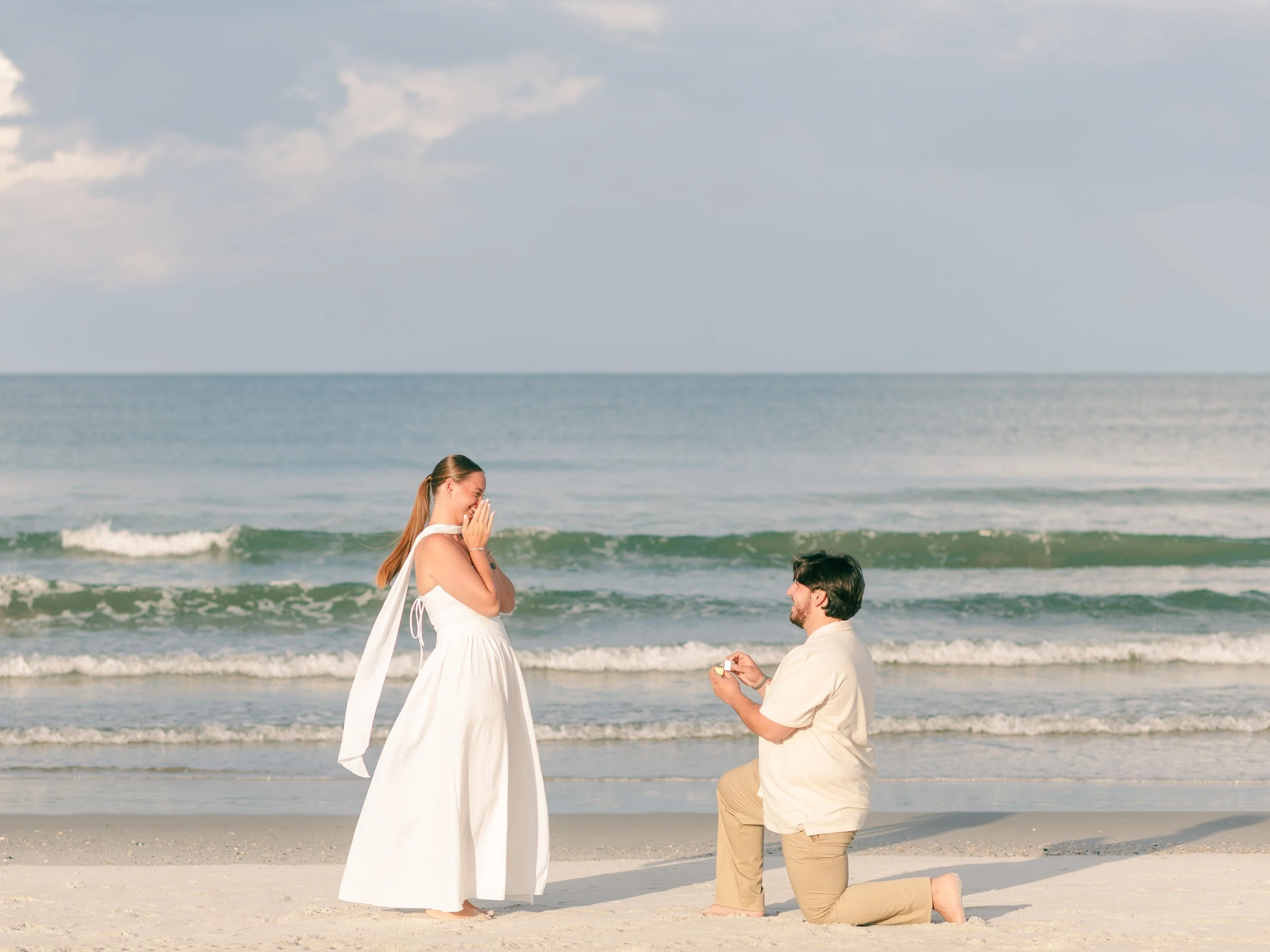 Man proposes to woman on the beach in Jacksonville, Florida with a diamond engagement ring