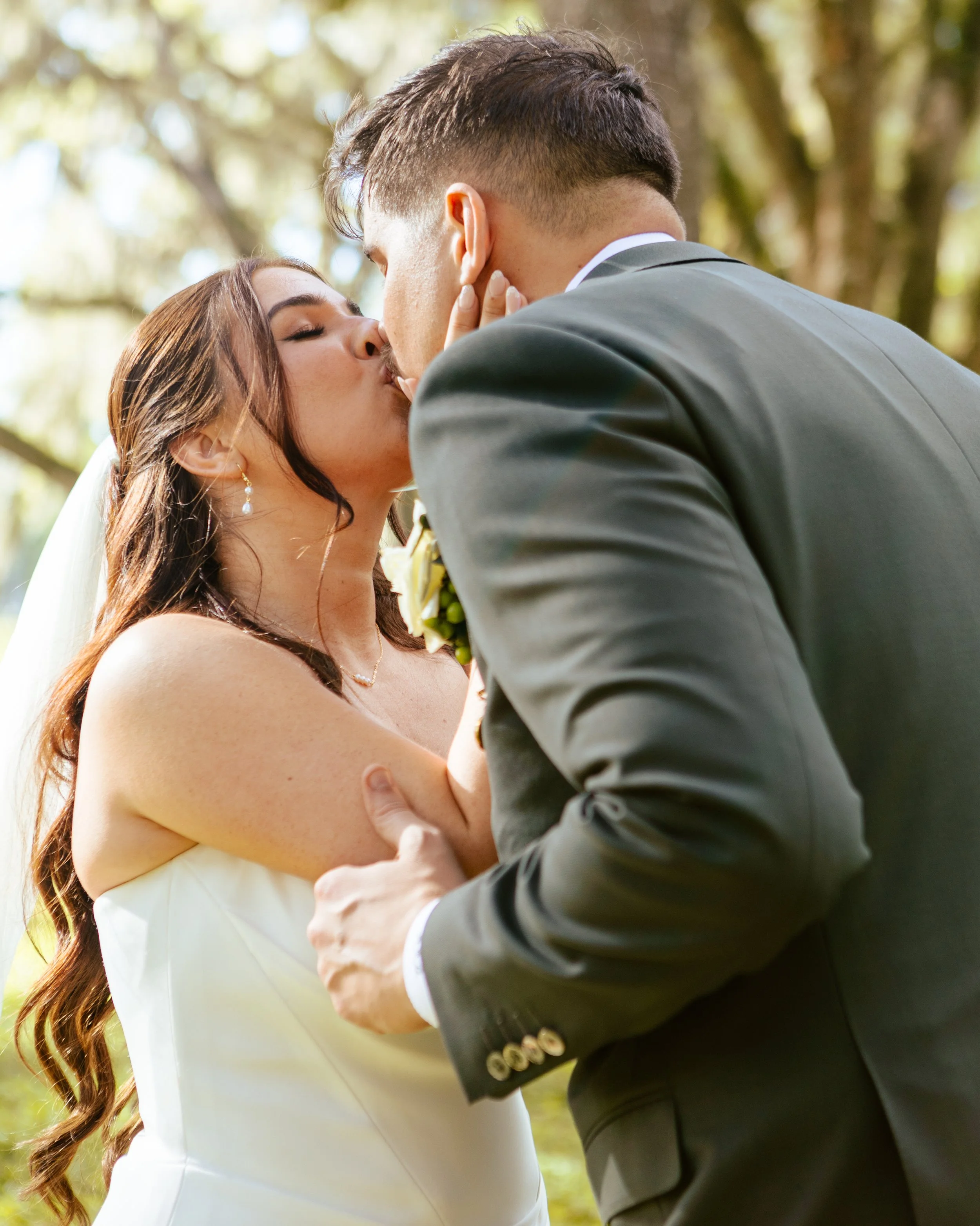 A newlywed couple kisses under a tree after their wedding ceremony in Ocala, Florida.