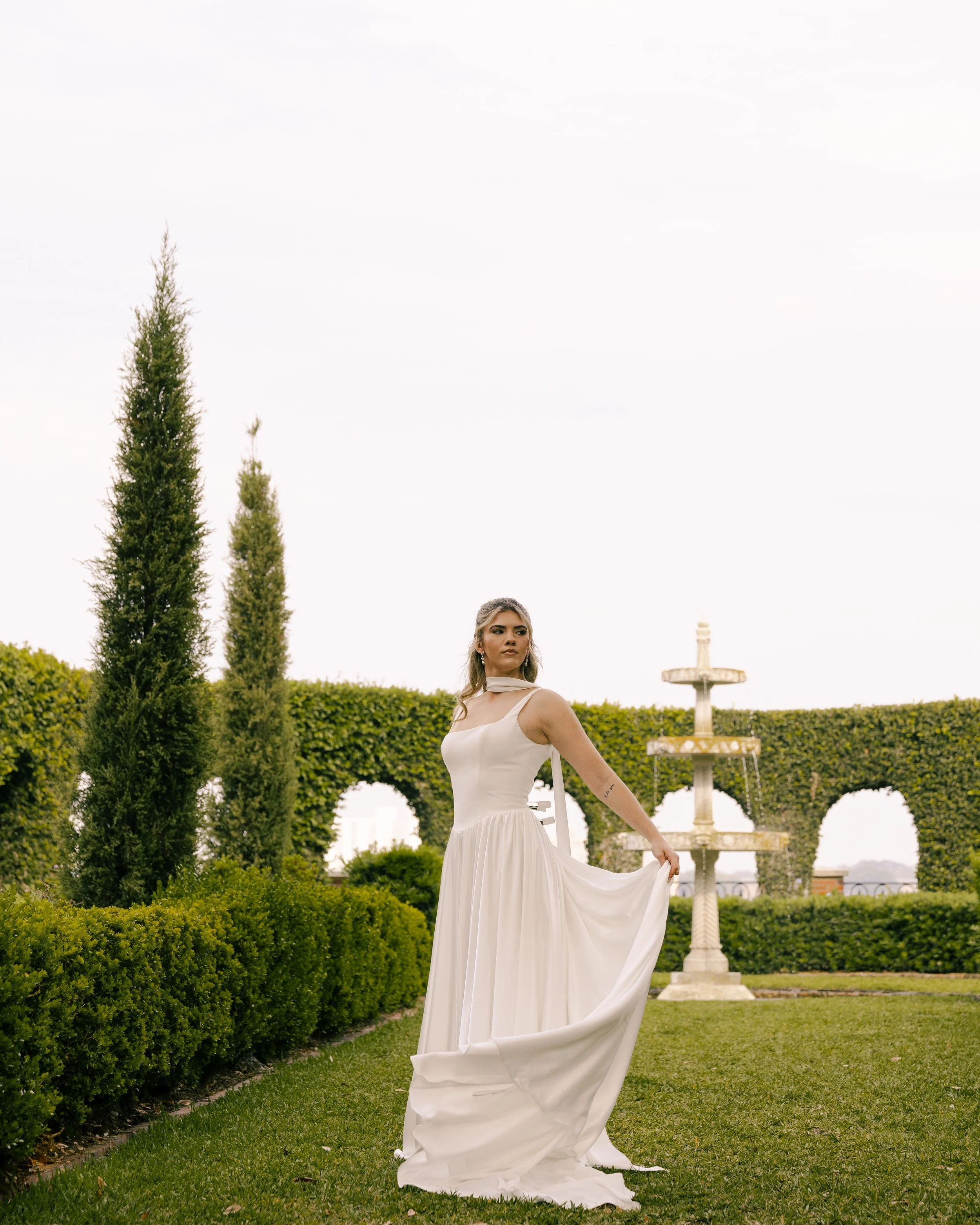 Bride poses editorially for wedding portraits at the Cummer Museum & Gardens in Jacksonville, Florida. She wears a dress from Love, a Bridal Boutique in Jacksonville Beach, Florida.