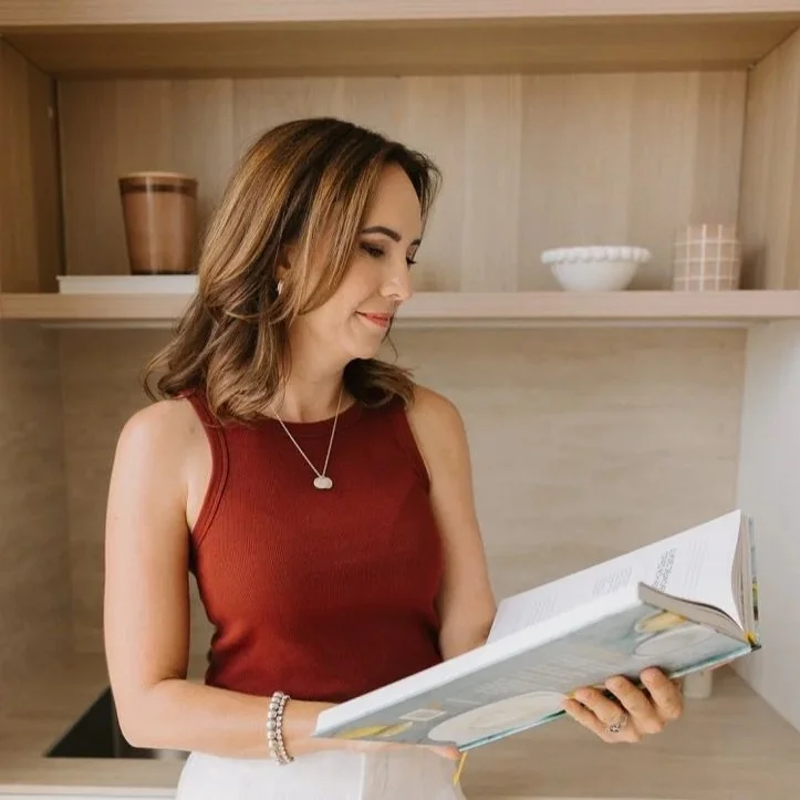 Cailie Ford reading a cookbook in her kitchen