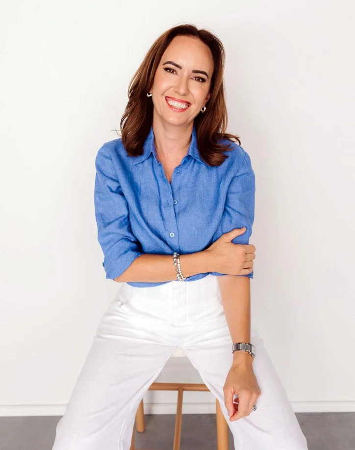 Cailie Ford smiling while sitting on a wooden stool
