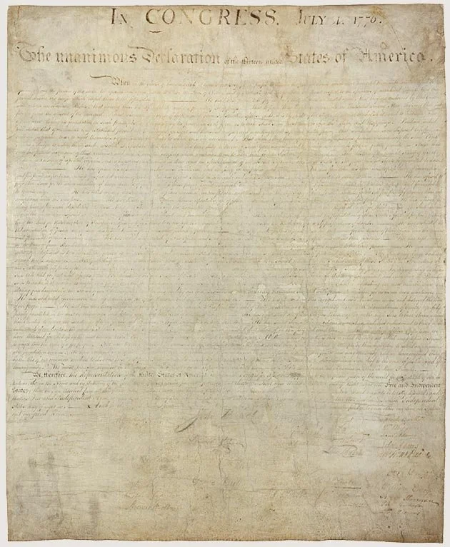 A historical document titled 'The Declaration of Independence' written in cursive handwriting on old paper, originating from the United States.