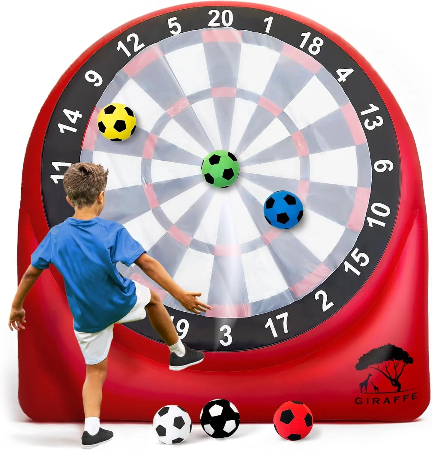 A boy in a blue shirt and white shorts playing soccer with three giant soccer balls on a red inflatable dartboard. The balls are colored yellow with black patches, green with black patches, and blue with black patches, positioned at various points on the dartboard. The dartboard has black, white, red, and green sections, with a giraffe logo and the word "GIRAFFE" in the bottom right corner.