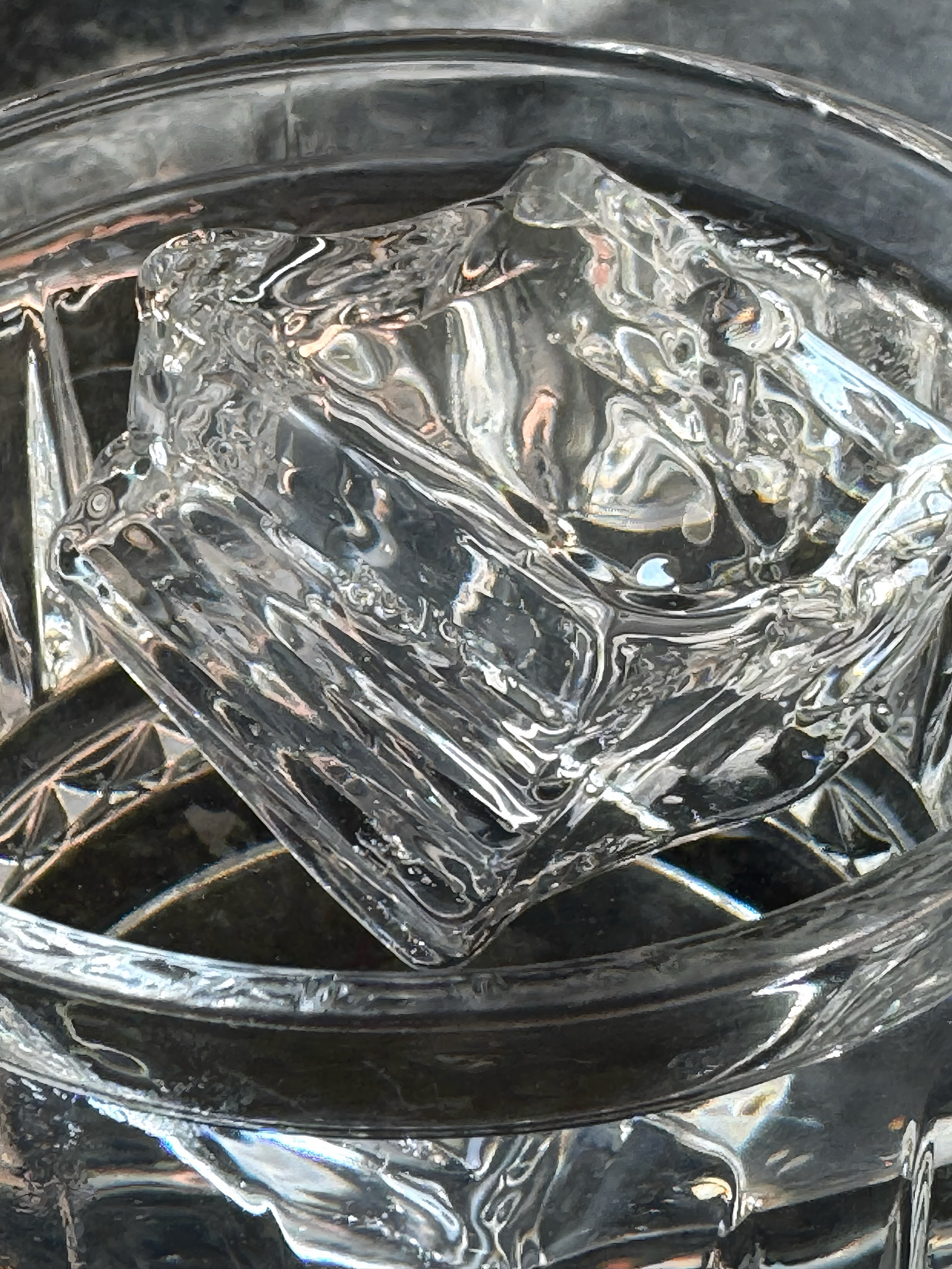 A close-up of a clear glass filled with ice cubes.