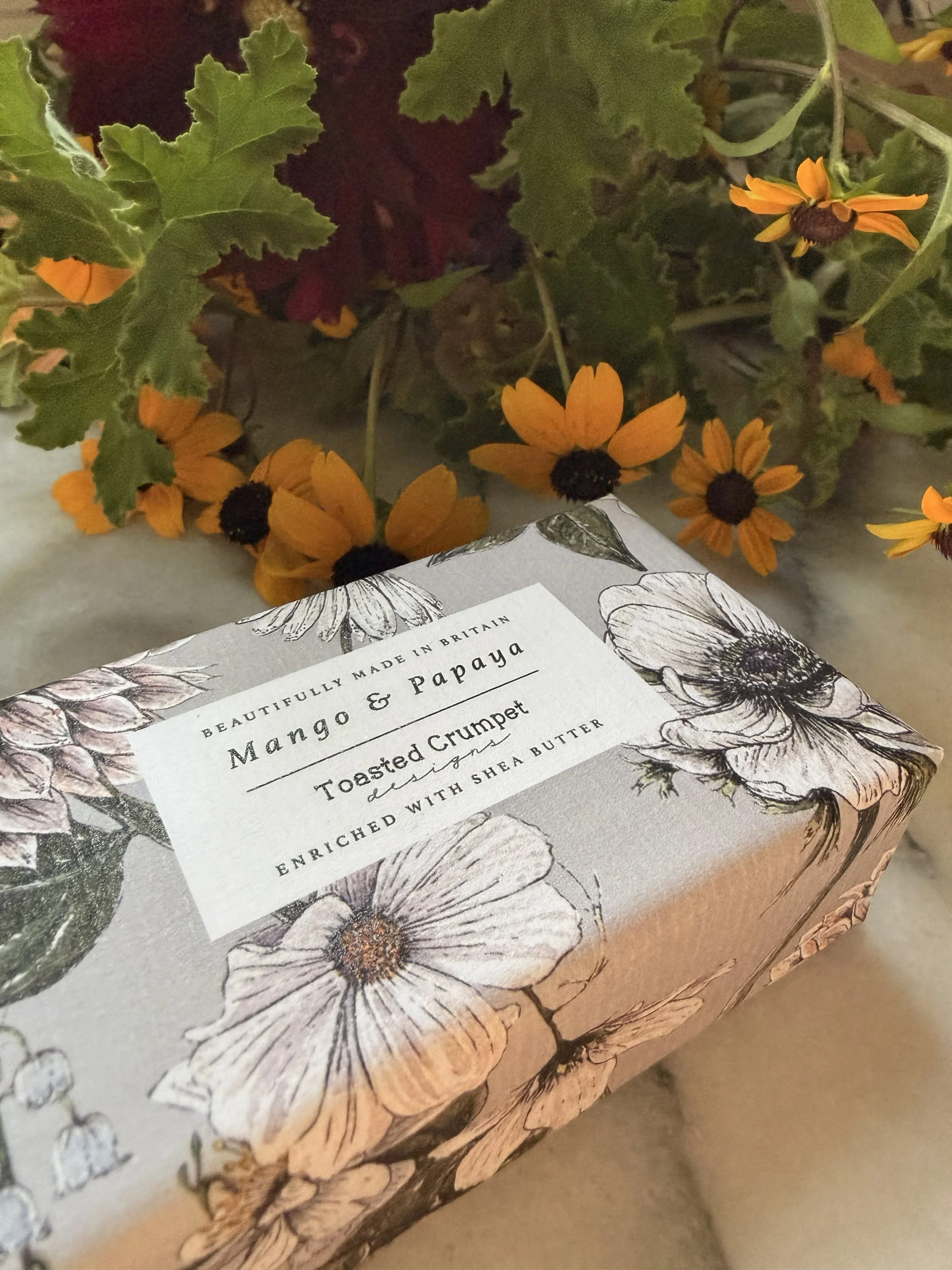 Side view of Toasted Crumpet's Mango & Papaya Soap with flowers
