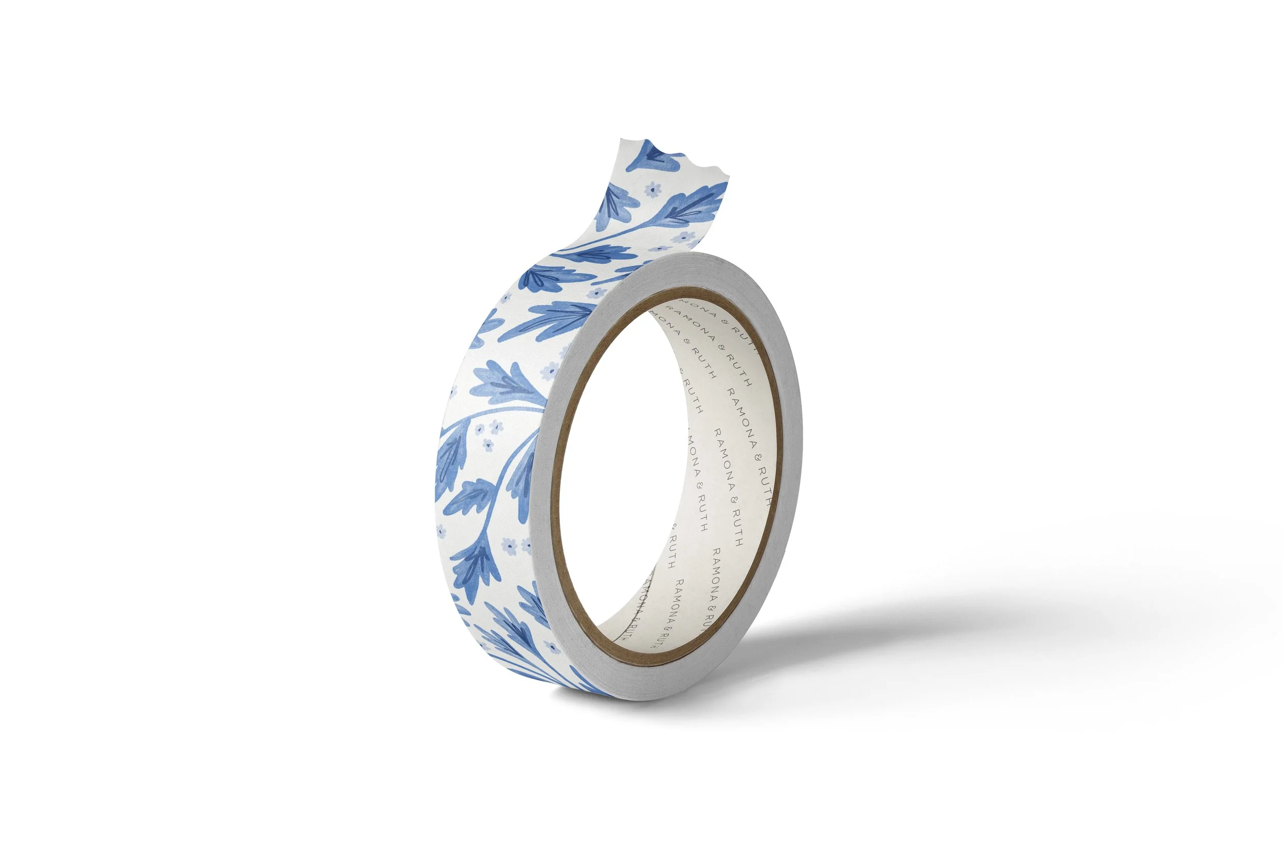 One roll of Ramona & Ruth's Blue Vines Washi Tape on edge with white background
