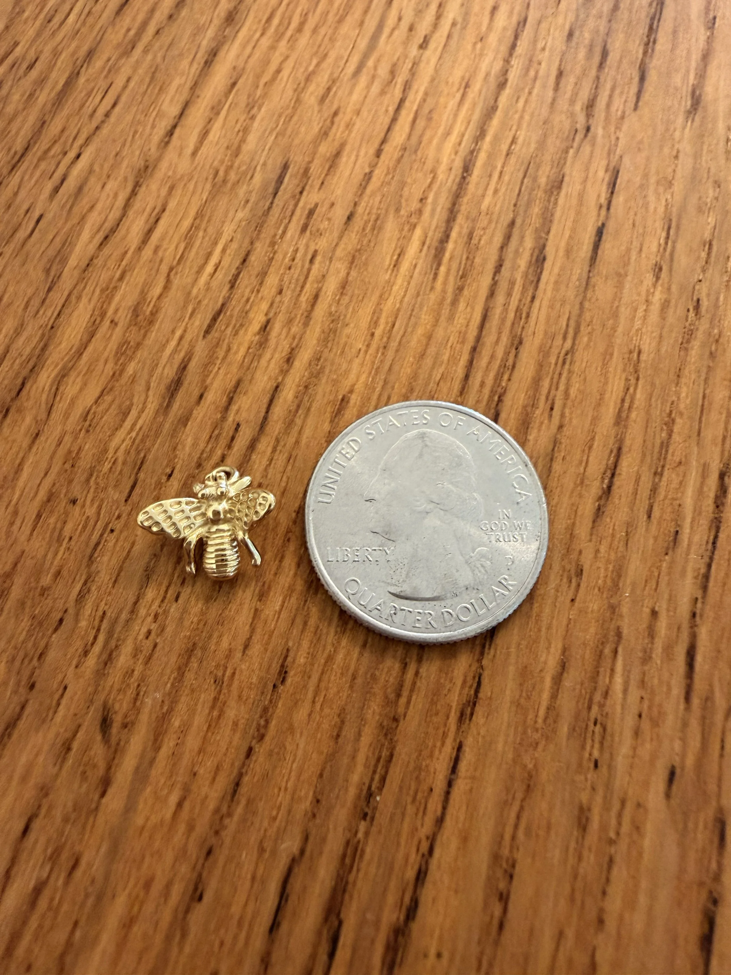 Bumble Bee Charm by House of Azelea with quarter on wood countertop