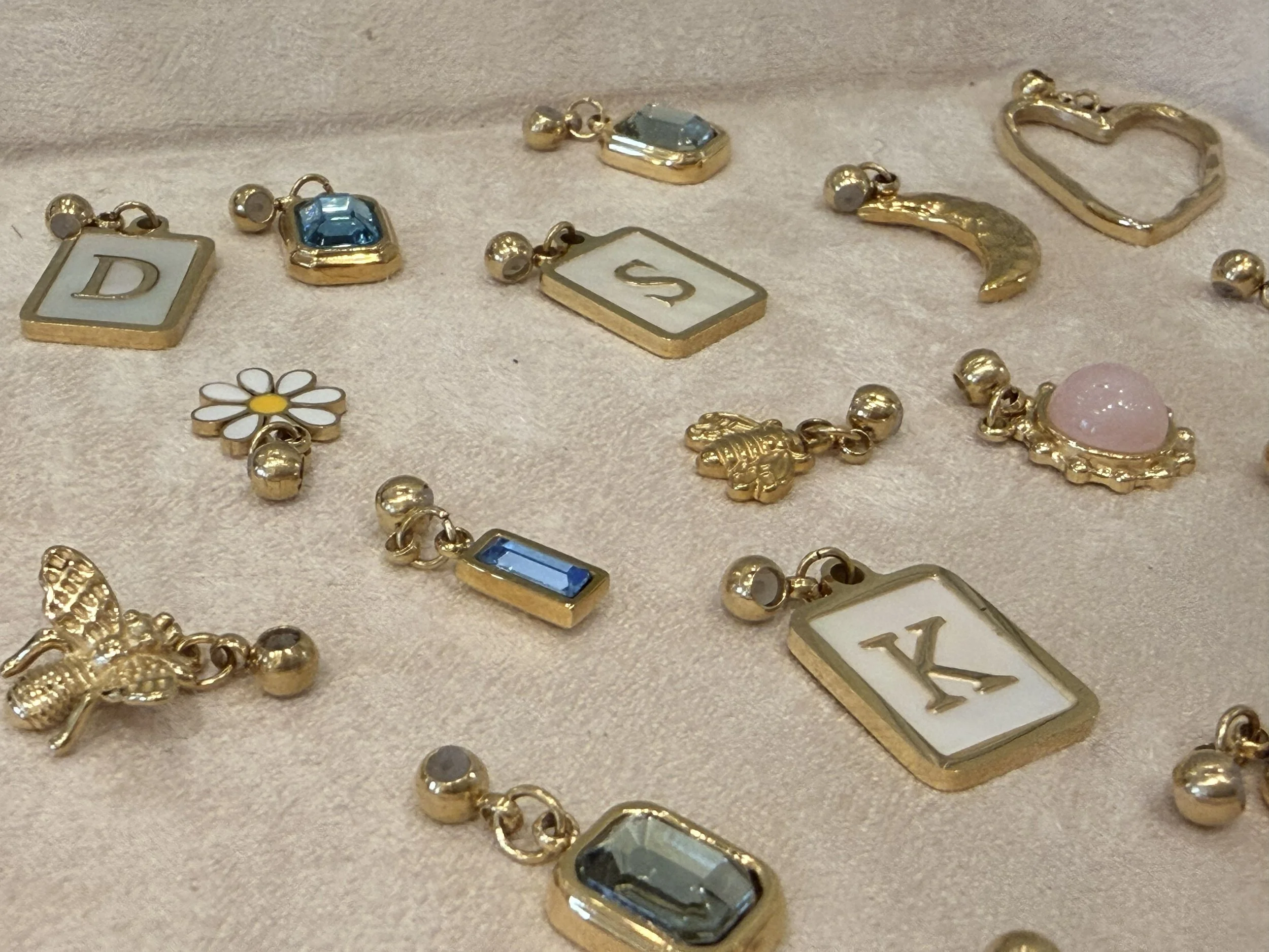 A variety of 14k gold PVD stainless steel charms by House of Azelea at Bloomie's Boutique. (Photo credit: Melissa Mitchell-Hooge)