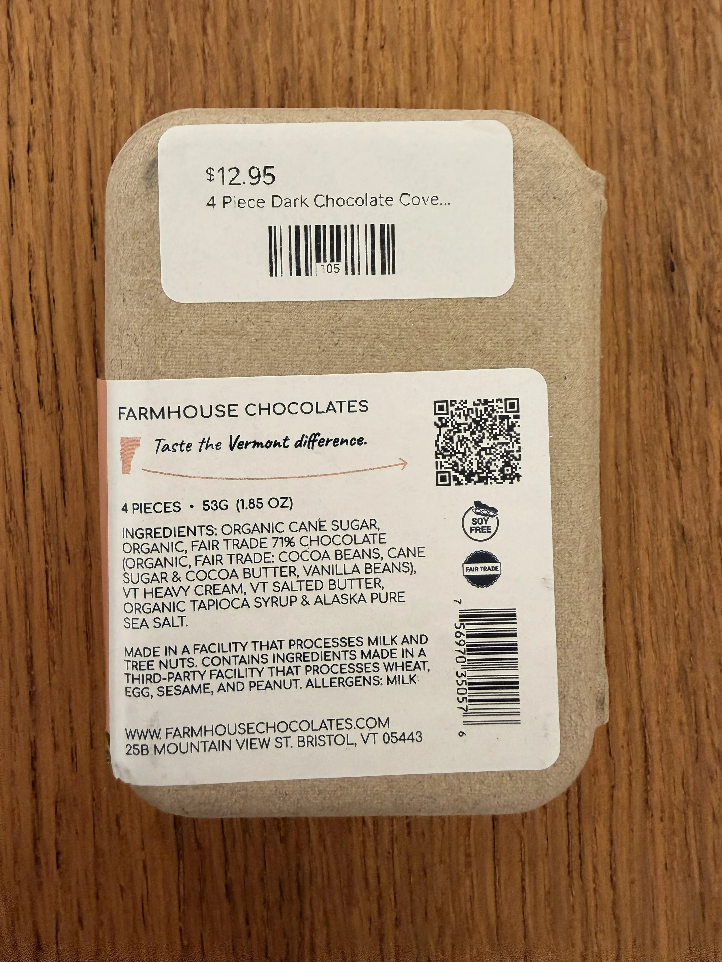 Back of Farmhouse Chocolates' 4-Piece Dark Chocolate Salted Caramels in recycled paper box on wood countertop