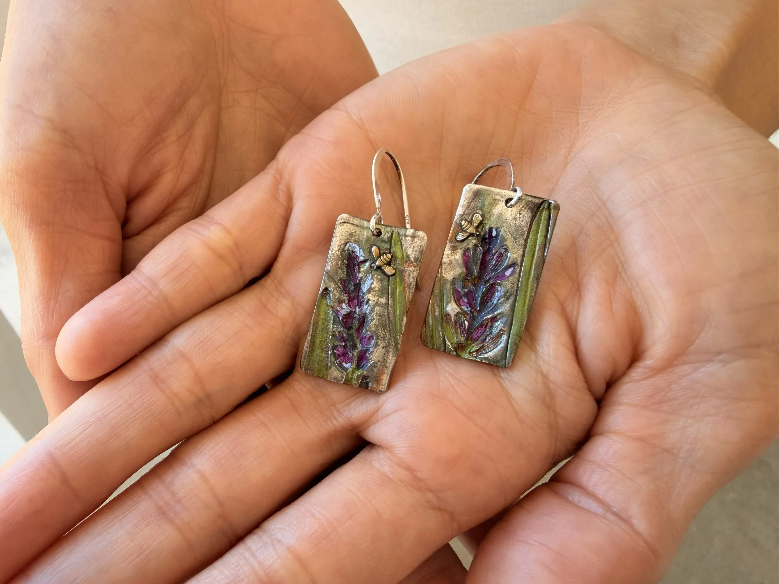 Close up of Tucci'Z Designs Fine Silver Lavender & Bees Earrings in model's hands
