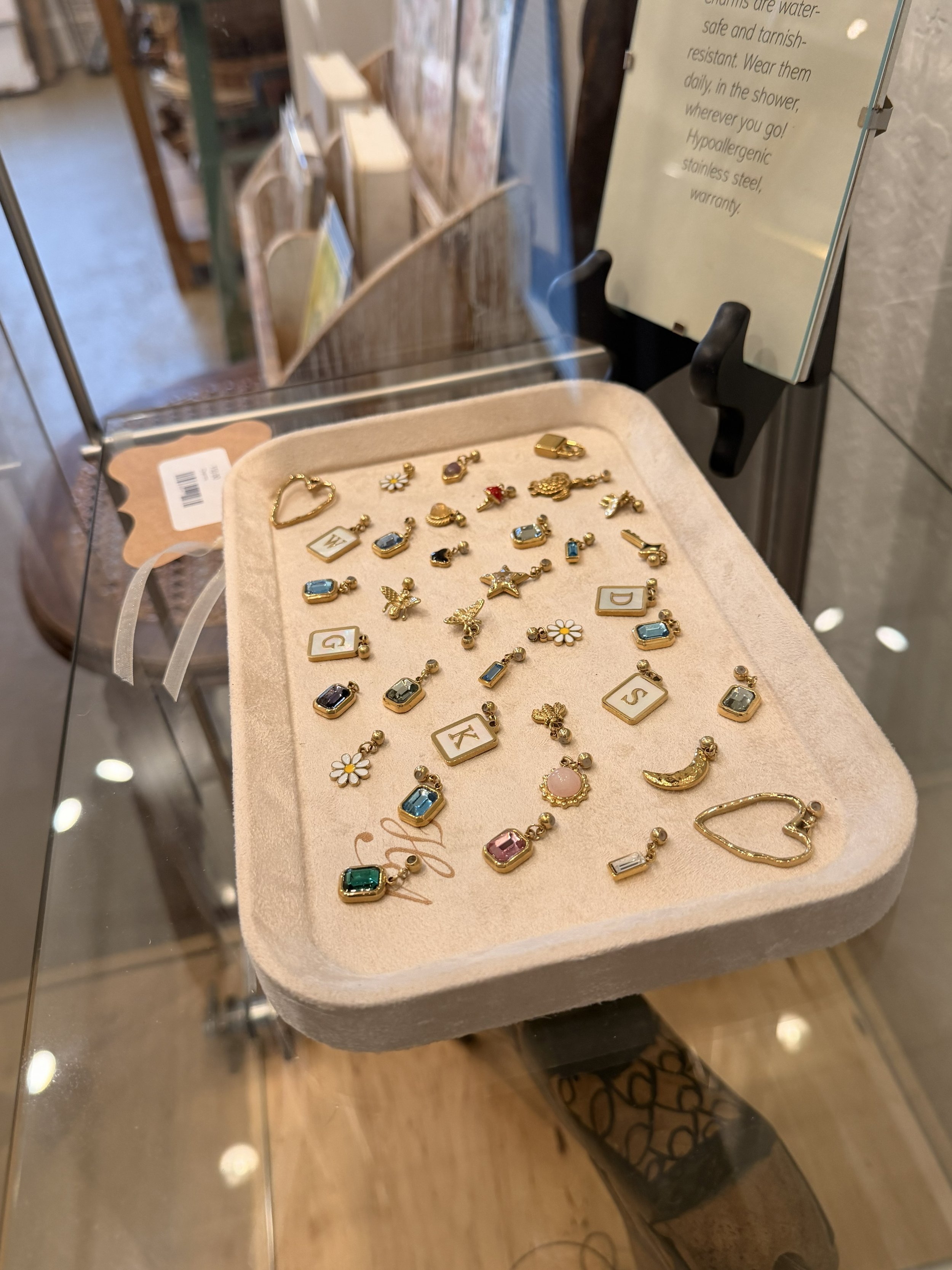 A variety of 14k gold PVD stainless steel charms by House of Azelea on display at Bloomie's Boutique. (Photo credit: Melissa Mitchell-Hooge)