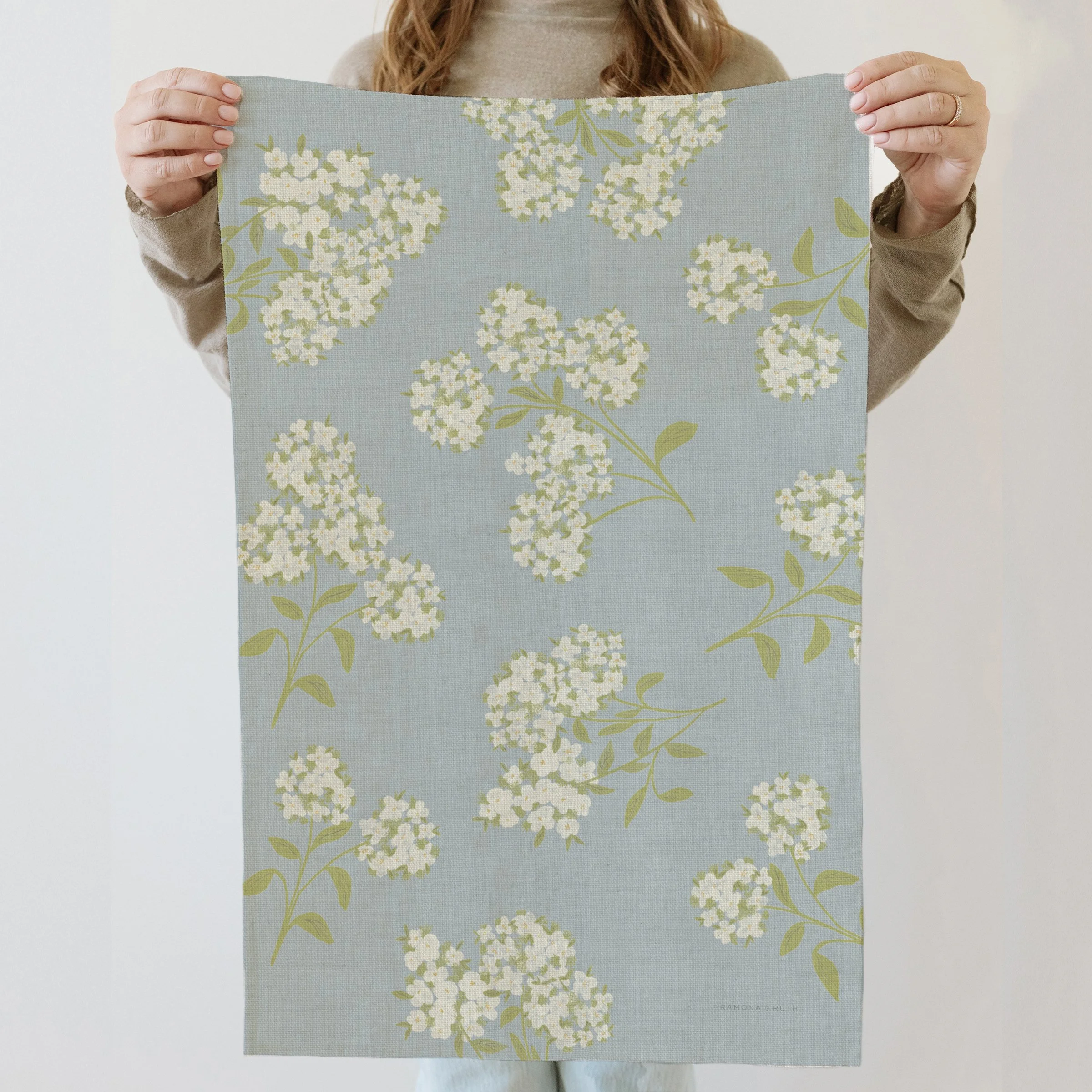 Model displaying Ramona & Ruth's Hydrangea Linen Tea Towel