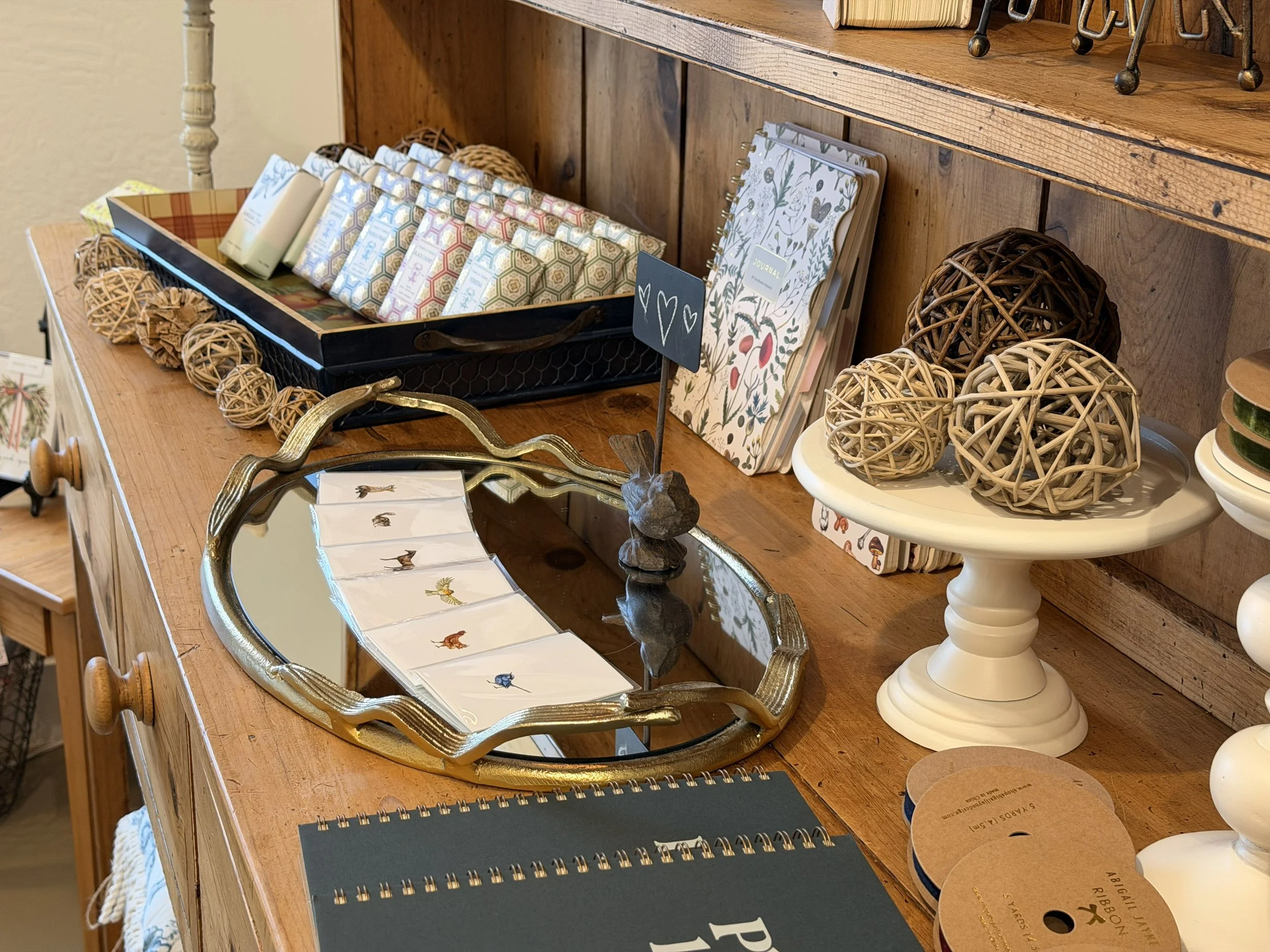 Terre á Terre French soaps, mini cards by Paintings for Hummingbirds, Greens and Flowers Art Journals by BV by Bruno Visconti, and various home decor items on display at Bloomie's Boutique. (Photo credit: Melissa Mitchell-Hooge)