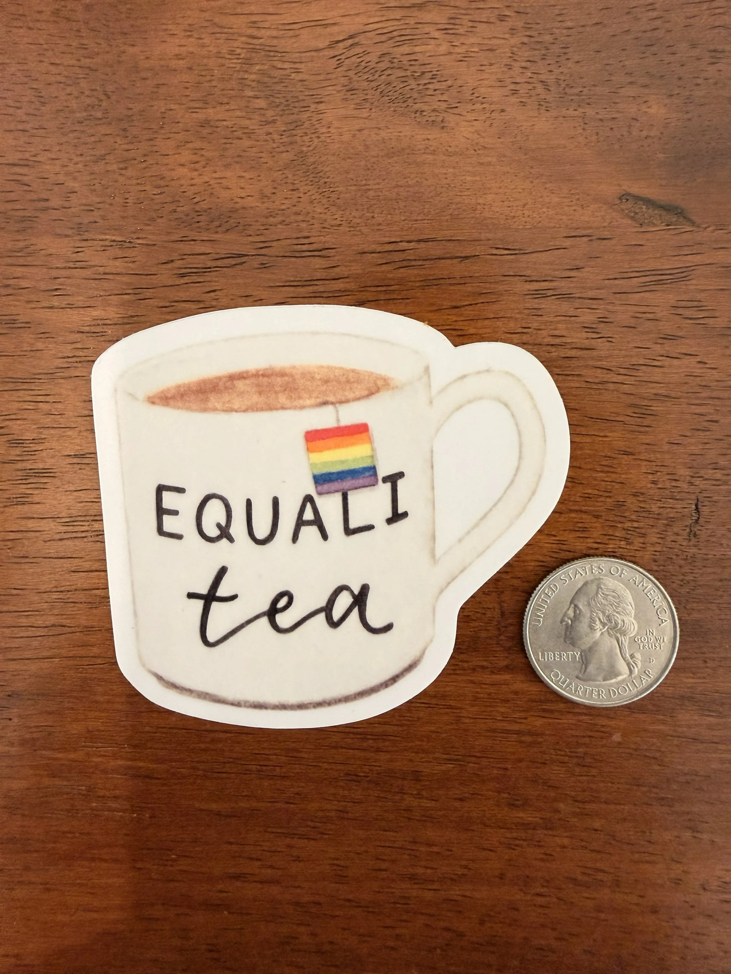 One Equali-Tea Vinyl Sticker with quarter on wood countertop