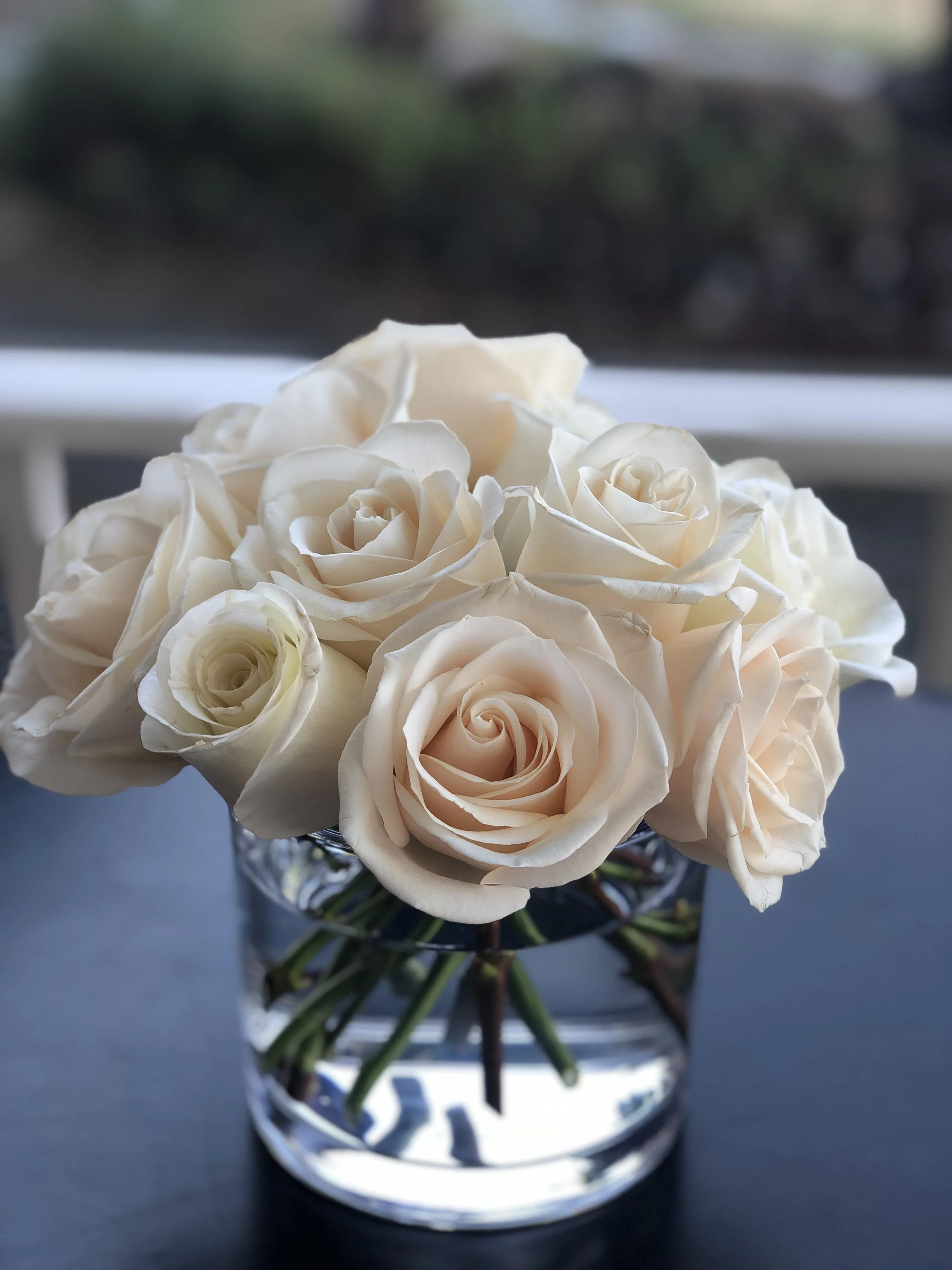 A classic, elegant arrangement of white roses in a clear, glass vase. (Floral design and photo credit: Melissa Mitchell-Hooge)
