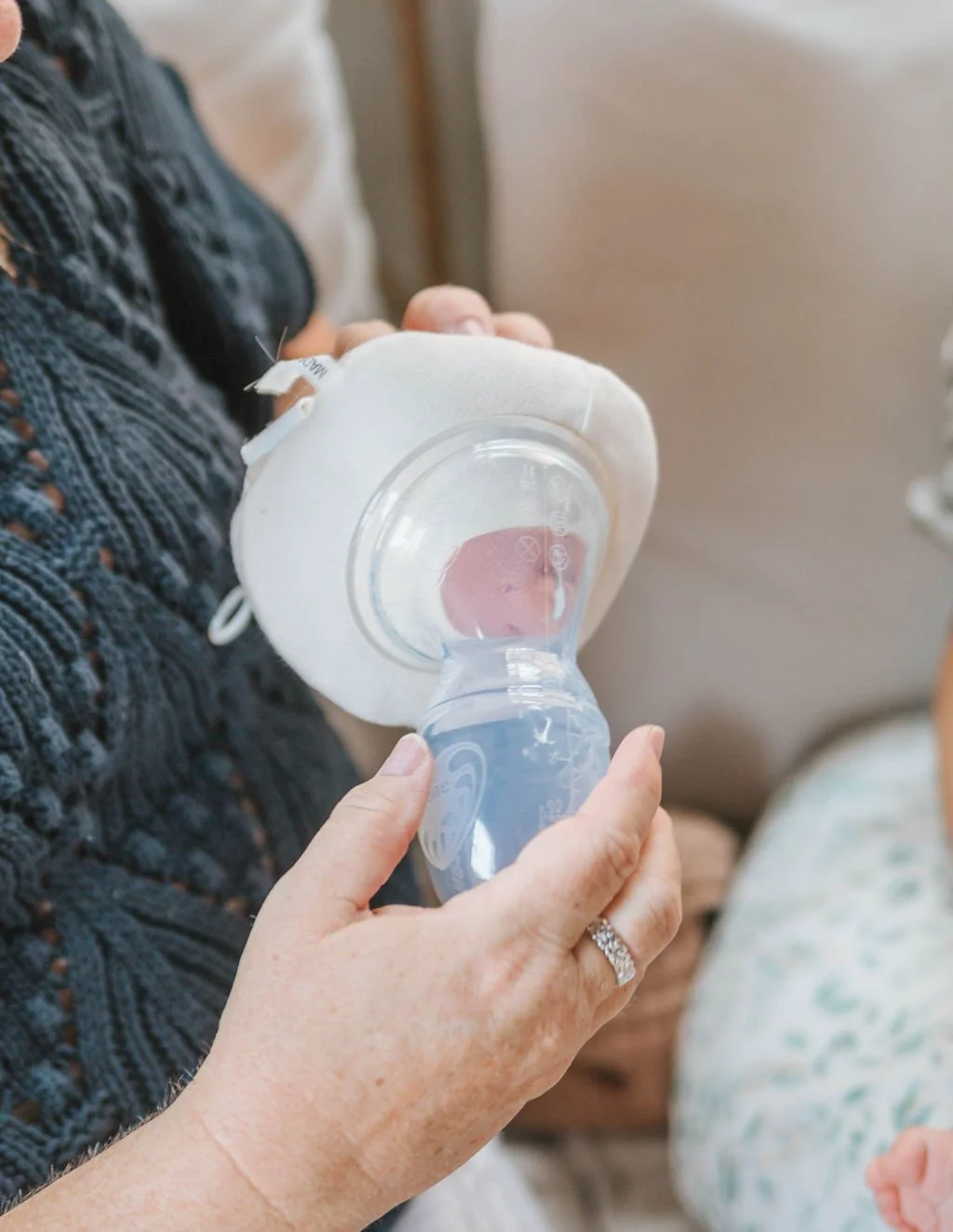 A lactation consultant demonstrates how to express milk to an expectant mother using lactation aides.