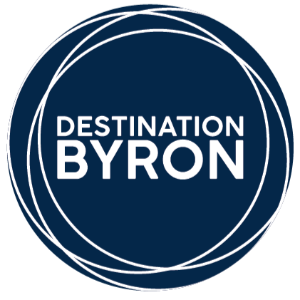 Logo with white circular lines and the text 'Destination Byron' in the center on a dark background.