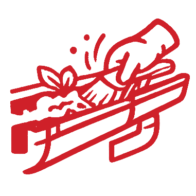 Hand placing a sprig of herbs into a wooden trough carving.