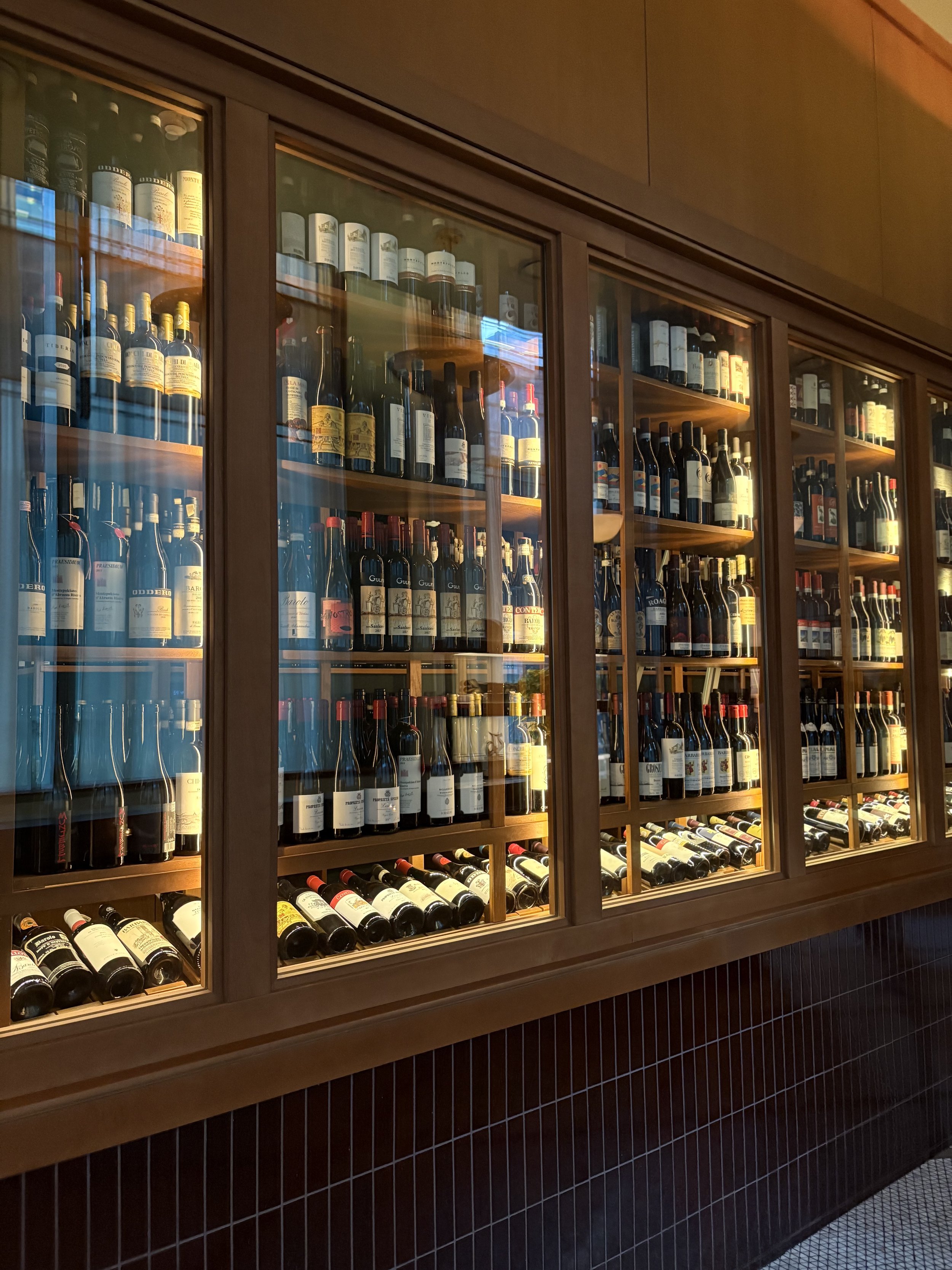 Curated extensive wine program with custom curved wine racking.