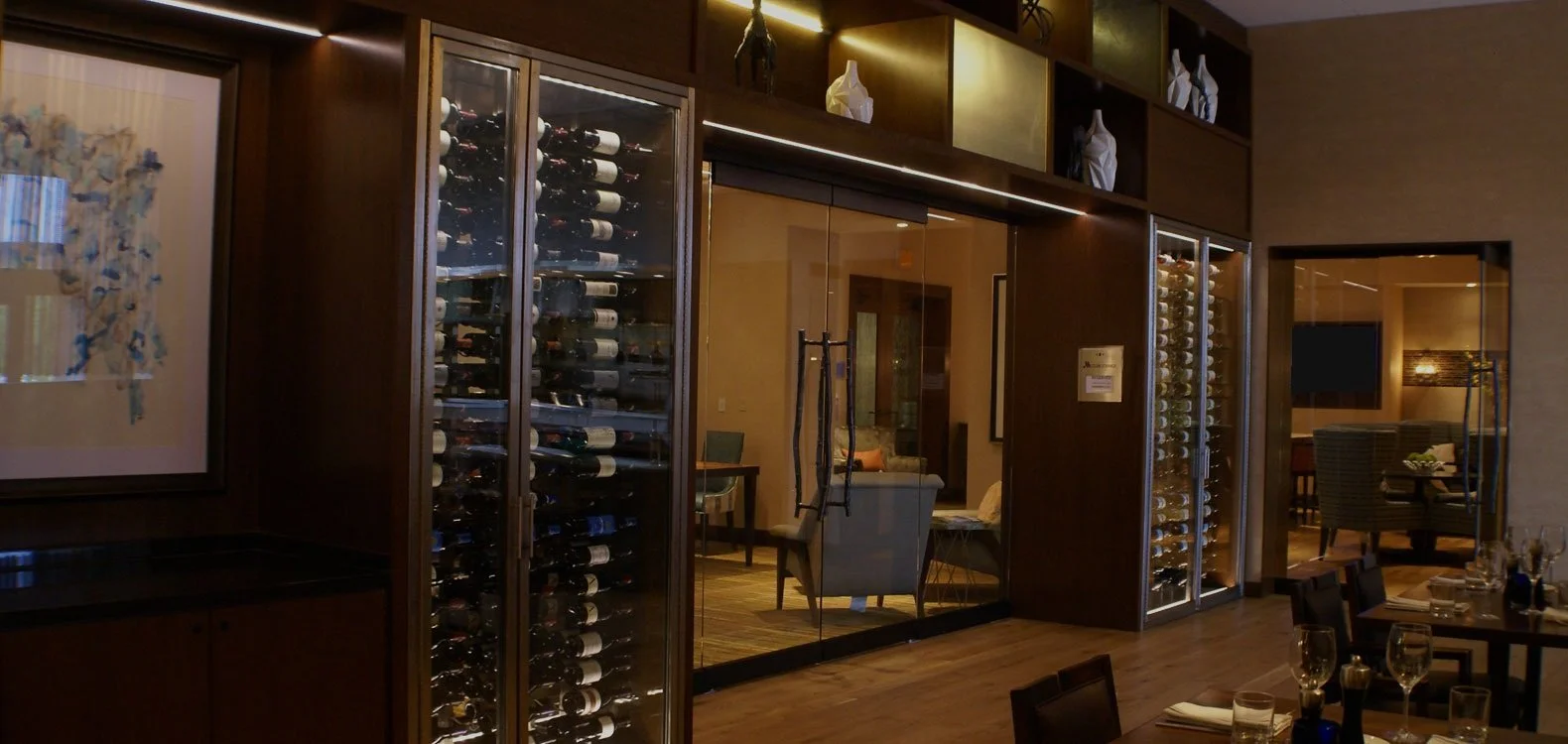 This installation frames a private dining space in a custom boutique hotel.  Integrated millwork and lighting enhance the wine collection while artfully suiting the design asthetic.