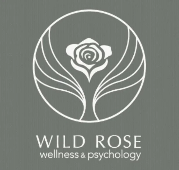 Logo for Wild Rose Wellness & Psychology featuring a stylized rose within a circle.