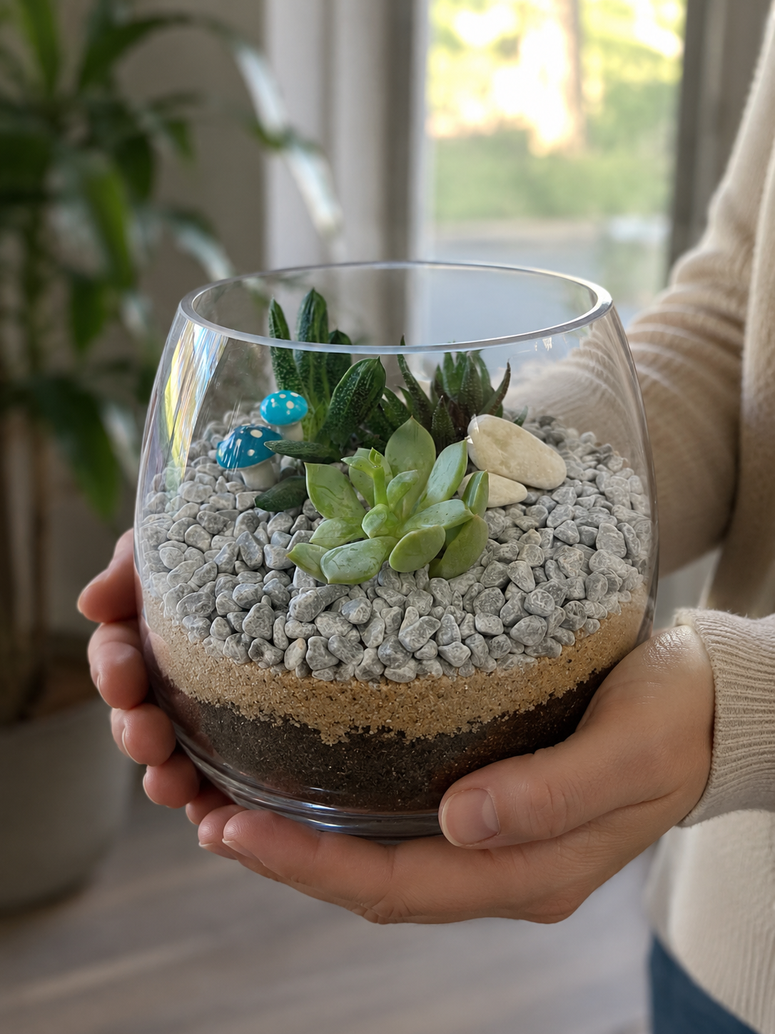 Handcrafted glass terrarium with layered soil, moss and indoor plants created during a terrarium workshop.
