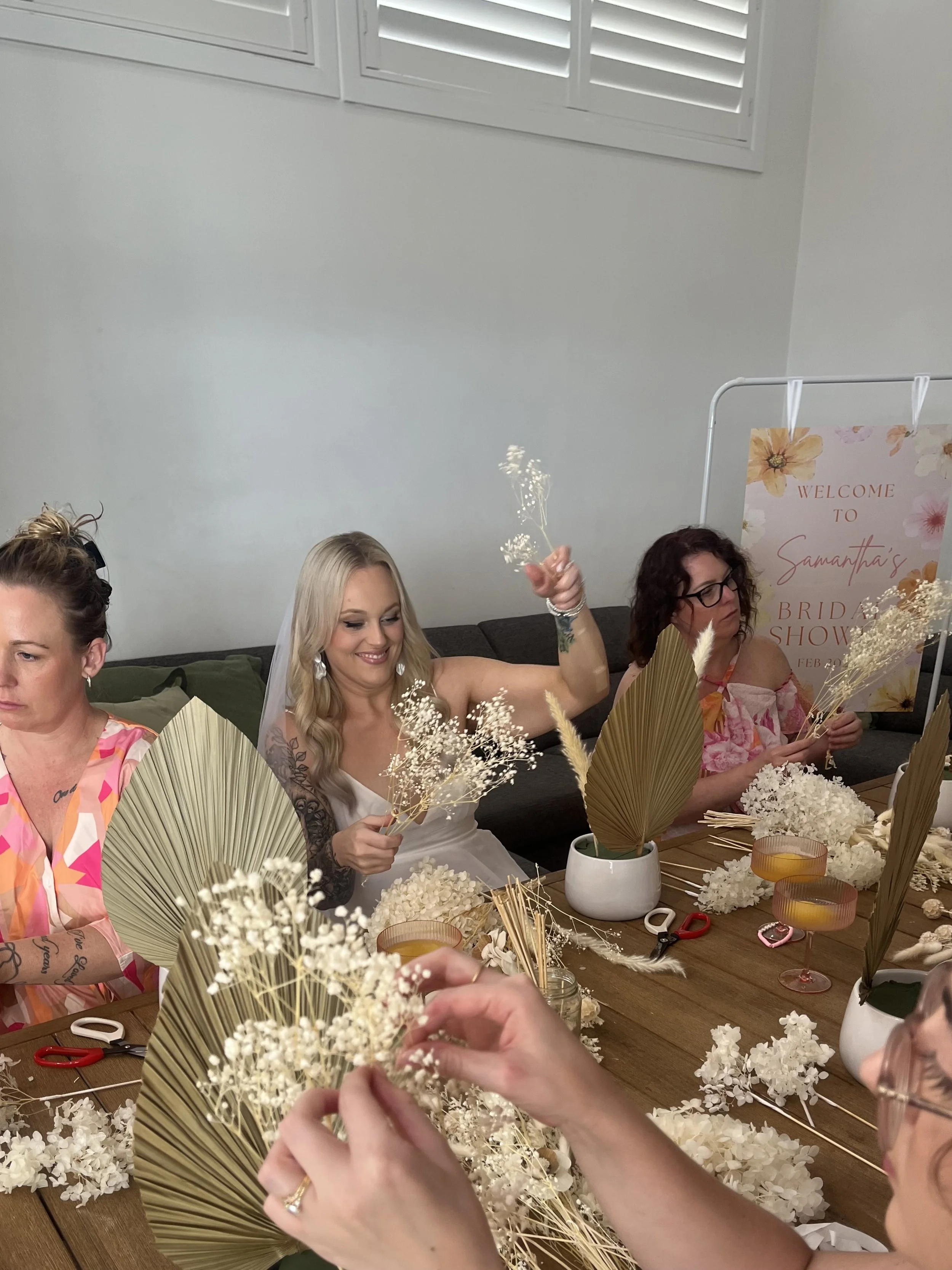 Guests enjoying a relaxed floral workshop together around a table.