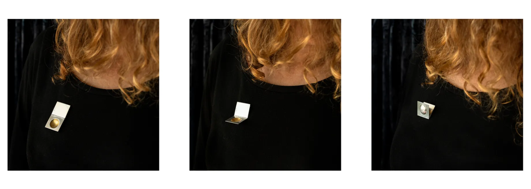 Close-up of a woman with curly red hair wearing a black top, showing three different lapel pins on her shoulder.