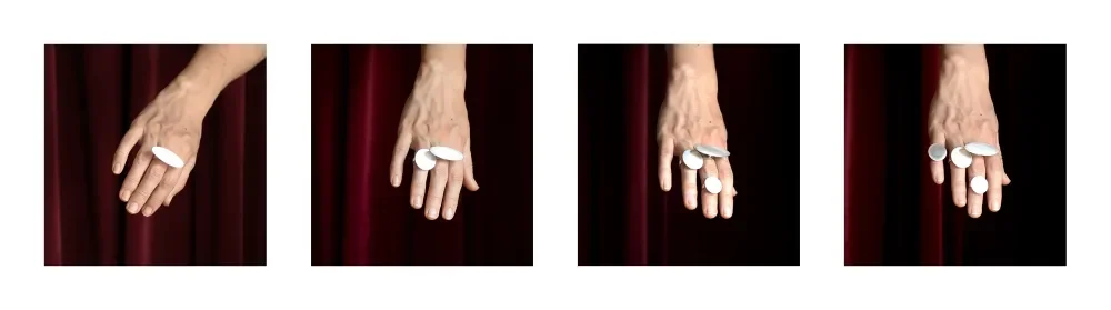 A hand with silver jewellery placed on the palm and fingers, shown in four different positions against a dark red background.