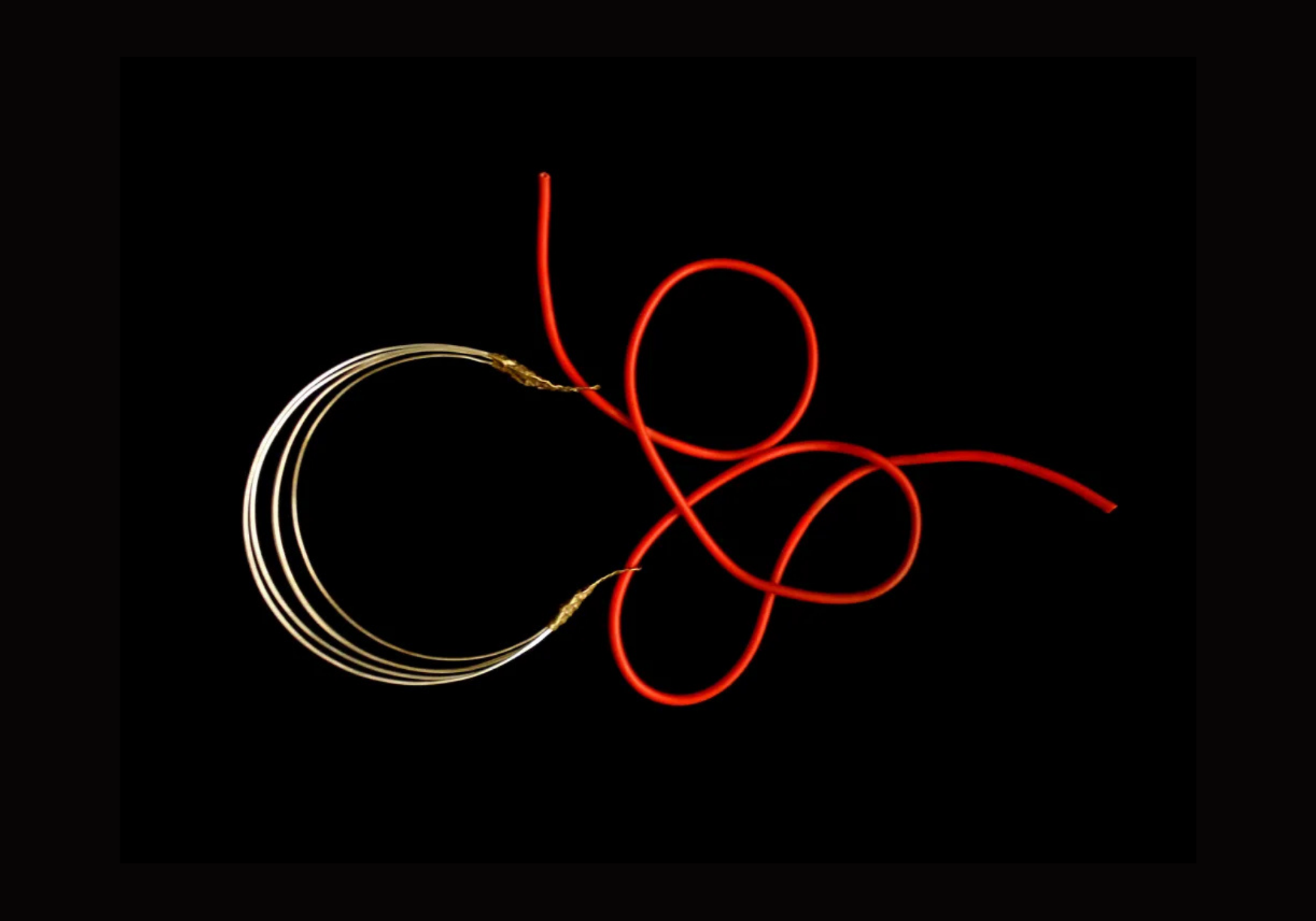 Red and white neon light tubes arranged in a chaotic, looping pattern on a black background.