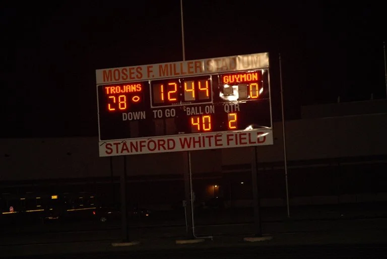 Scoreboard at Stanford White Field displaying 12 minutes and 44 seconds left in the game. The Trojans are leading 28-0 against Guymon. Temperature is 28 degrees Fahrenheit. The scoreboard shows 40 yards to go for the first down, second quarter, and t