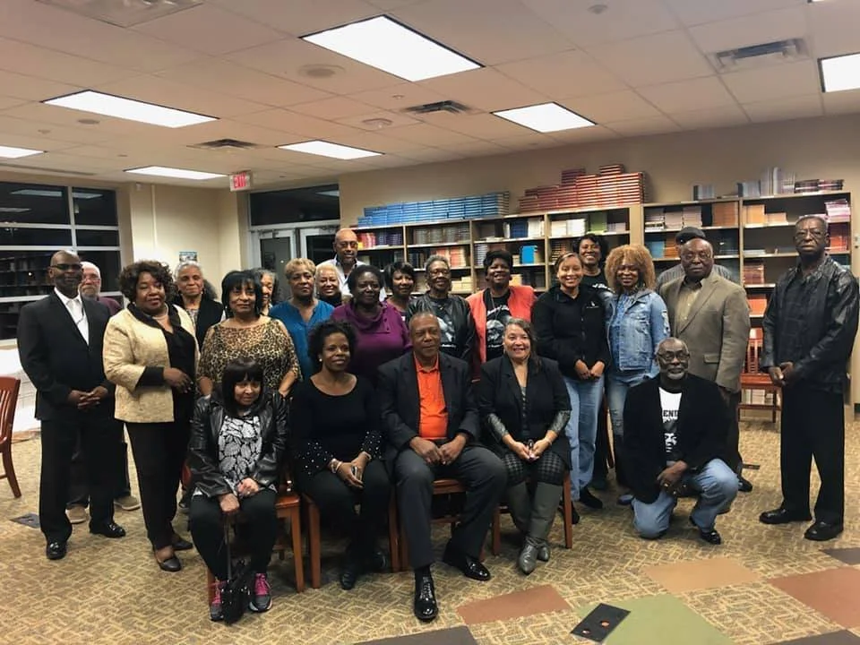 Group of diverse people posing for a photo in a bookstore or library