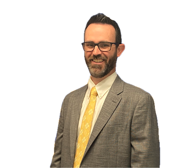 A man with glasses, a beard, and short dark hair, smiling, wearing a gray suit, white shirt, and yellow tie, against a black background.