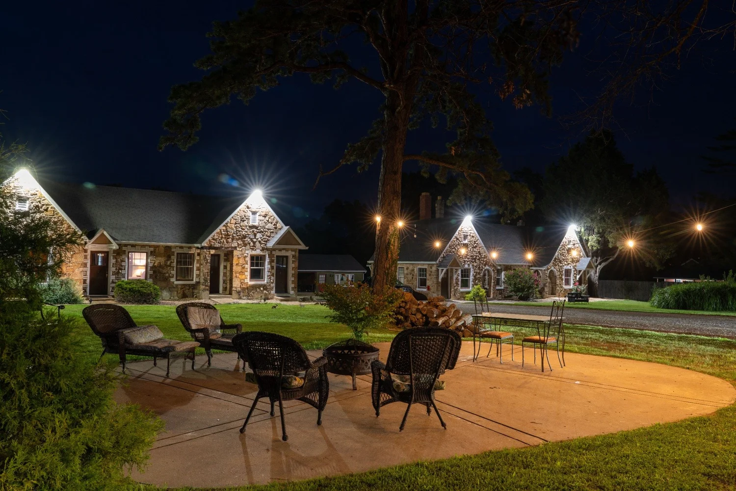 Illuminated stone cottages and the Wagon Wheel Motel outdoor guest patio after dark