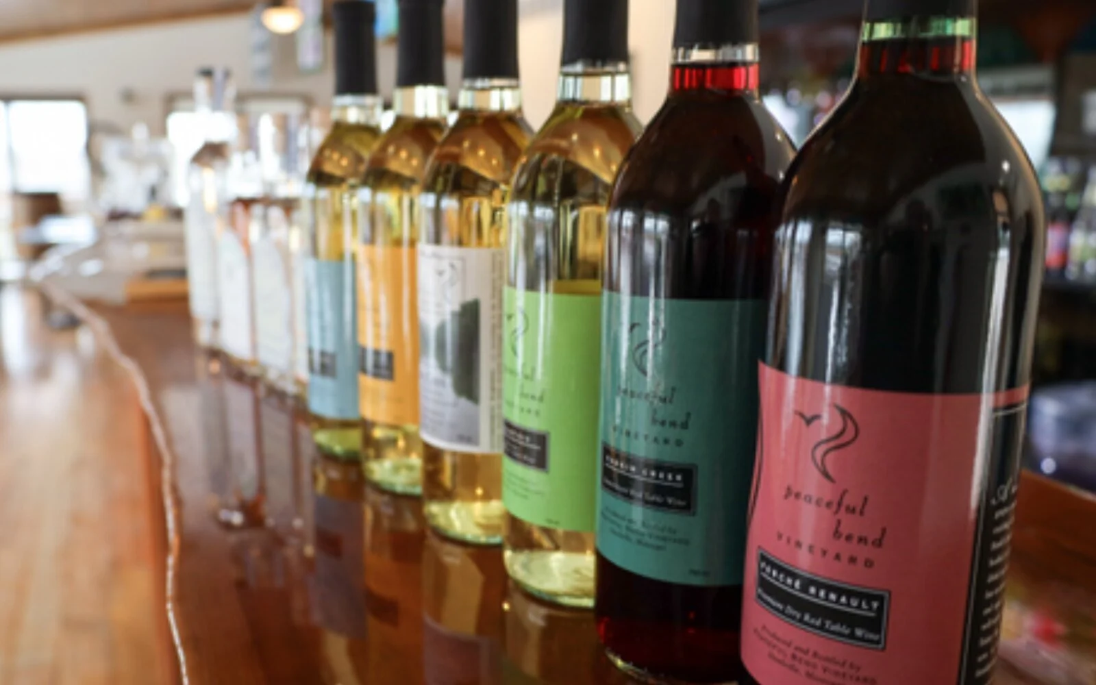 Bottles of handcrafted wine lined along the tasting-room bar at Peaceful Bend Winery near Steelville, Missouri.