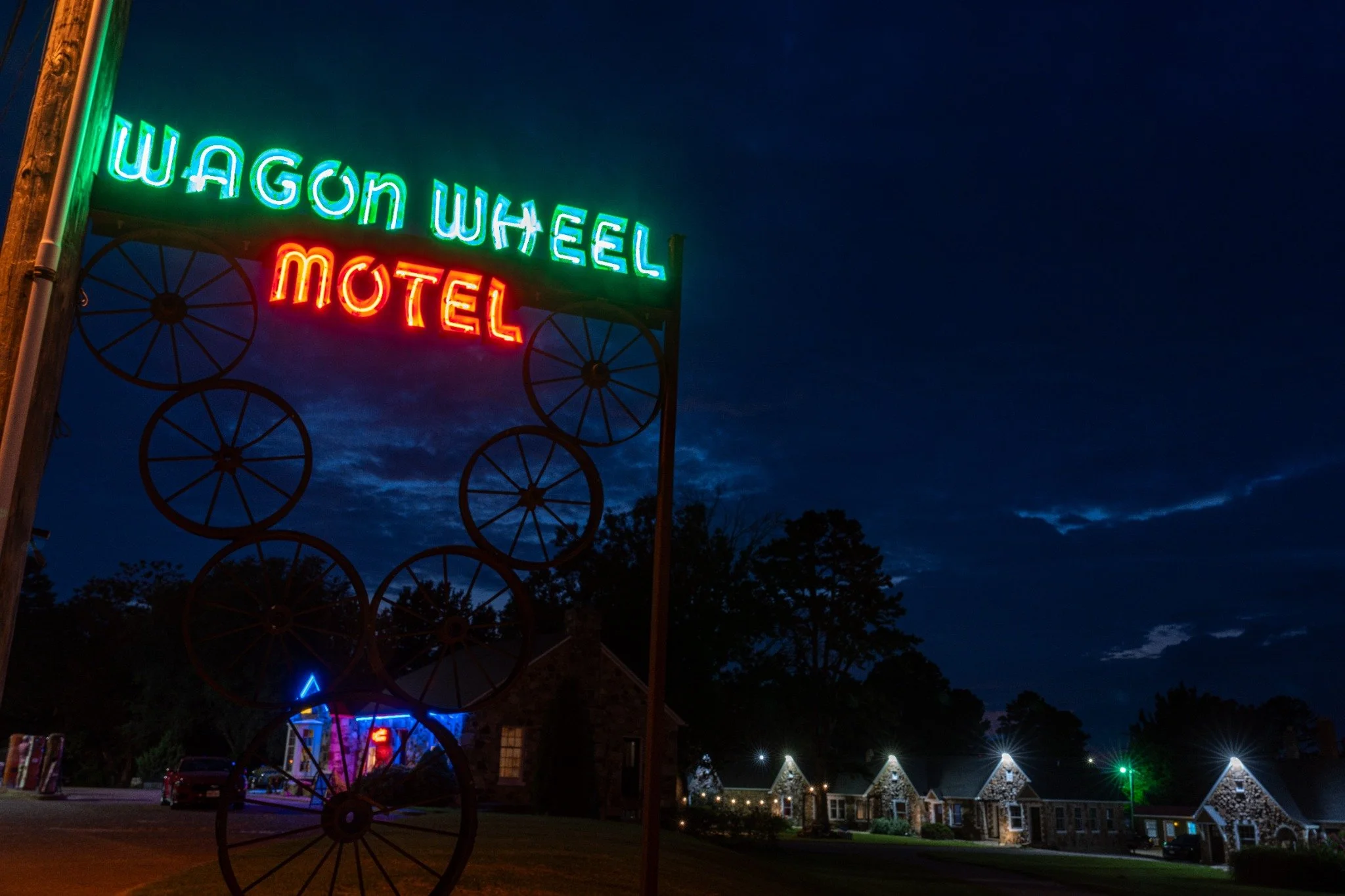 Wheel-themed Wagon Wheel Motel neon glowing against the evening sky along Historic Route 66.