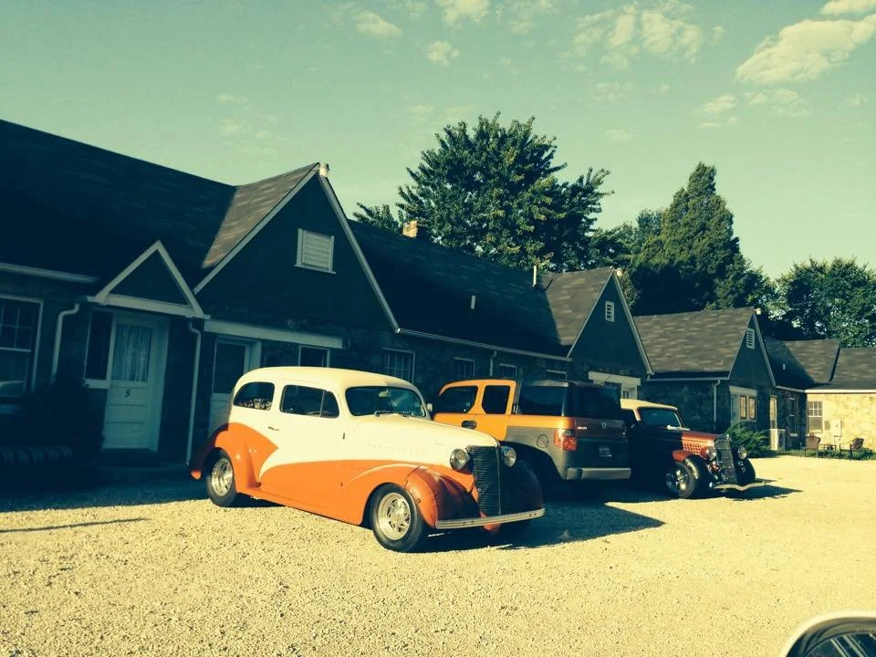 Vintage automobiles gathered beside the Wagon Wheel Motel’s Ozark sandstone guest buildings