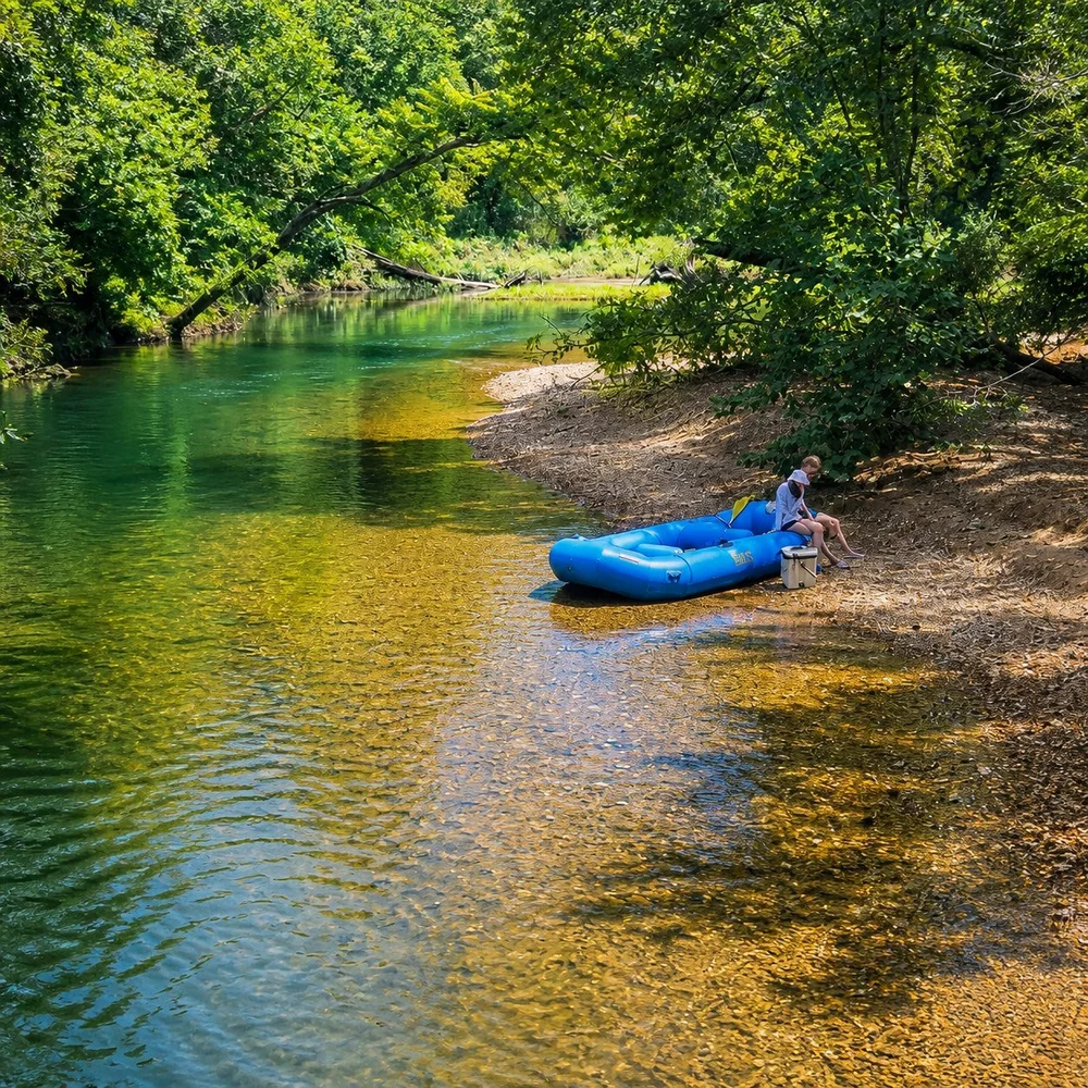 Blue raft beside the wooded Meramec River near Steelville, Missouri