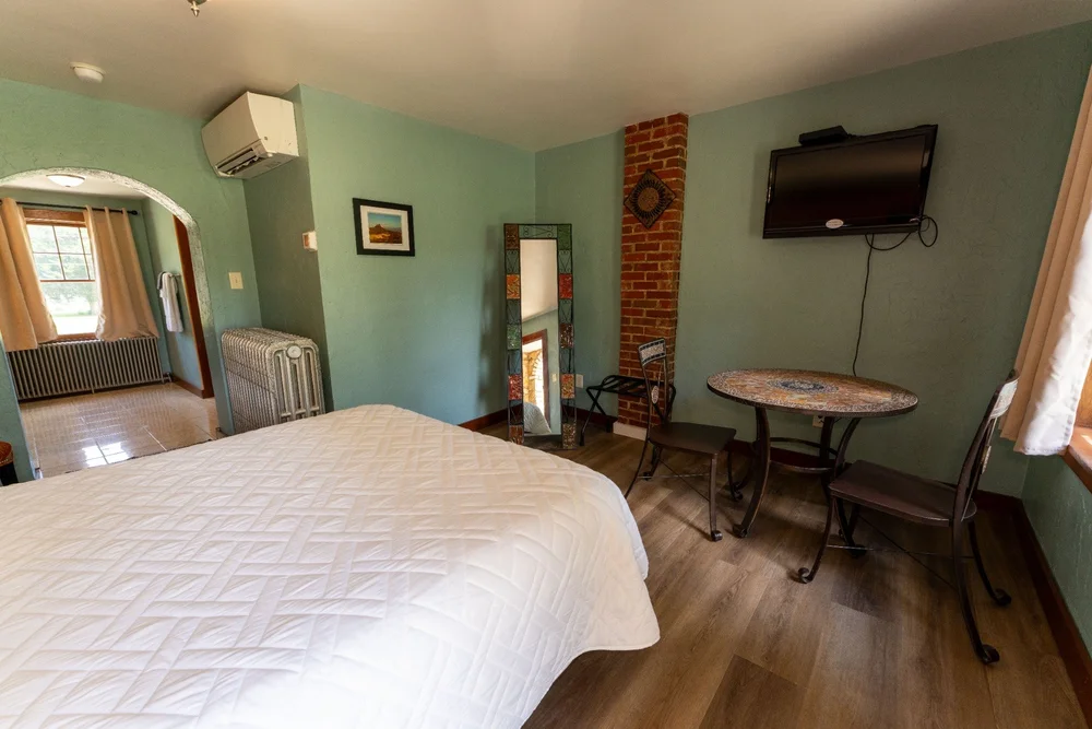 One-bed Wagon Wheel guest room with hardwood floors, exposed brick and a sitting area