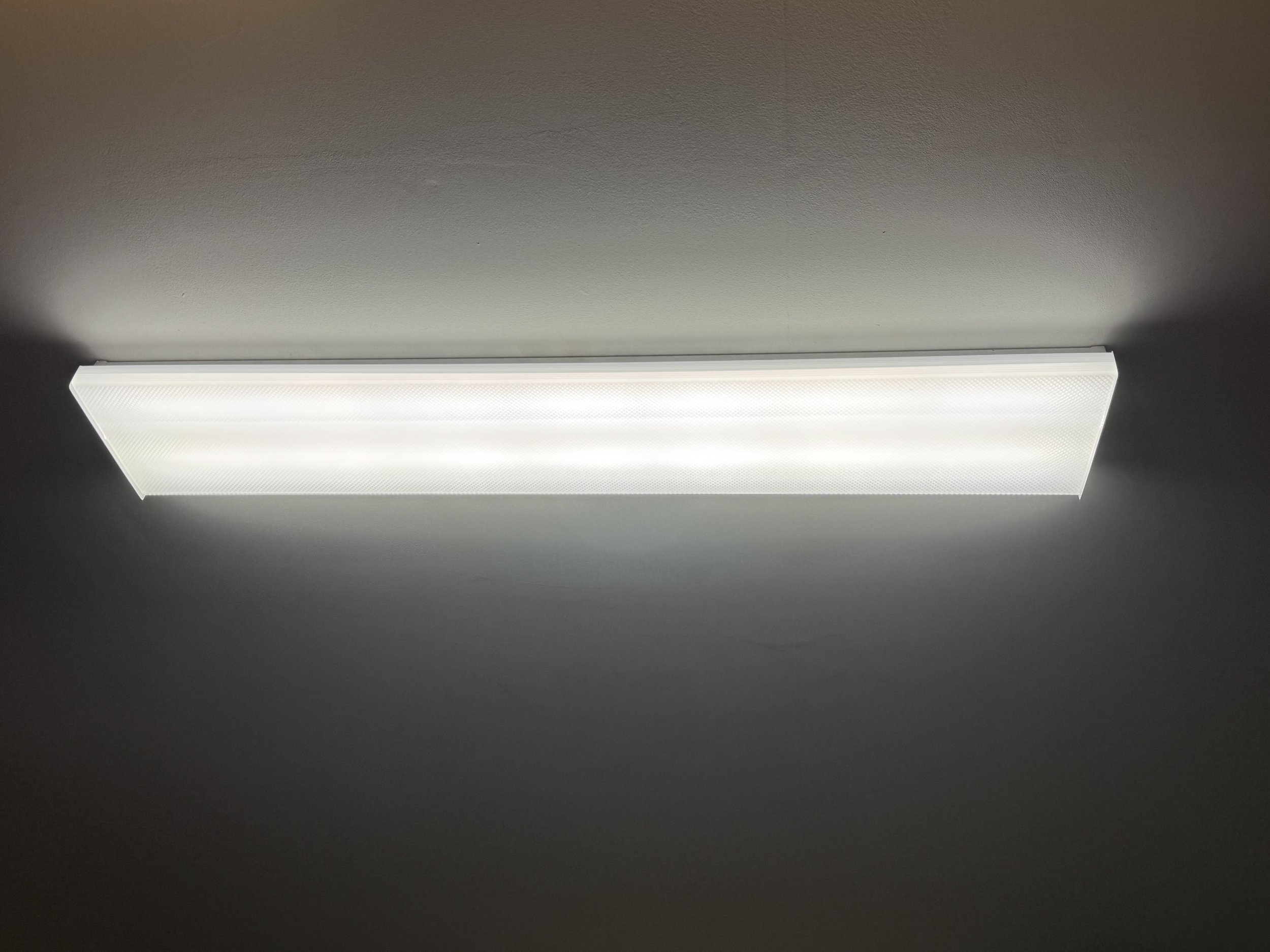 Closed rectangular LED ceiling light fixture on a gray ceiling.