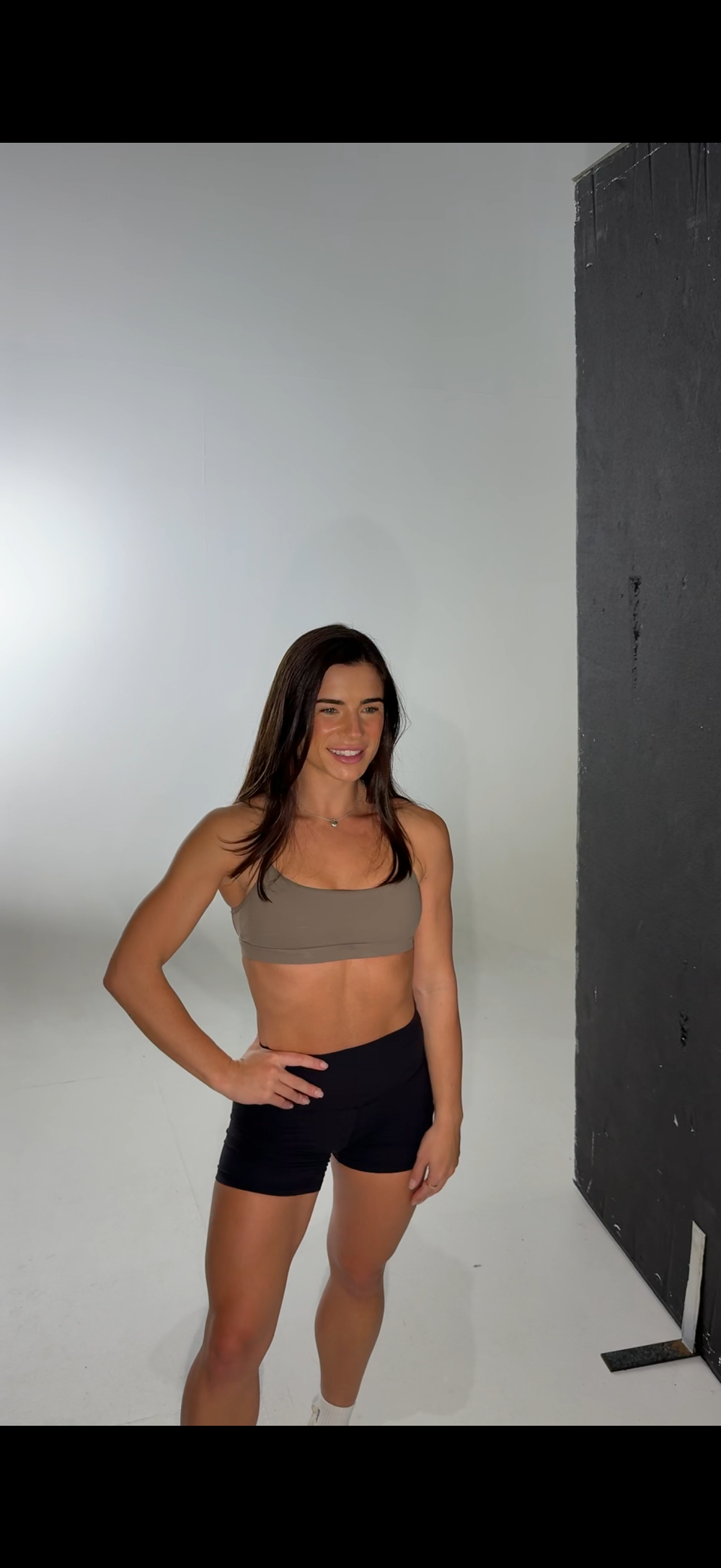 Maddi at a studio photoshoot in training gear, smiling