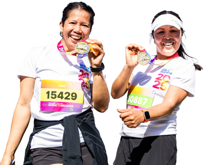 Two women in athletic running attire holding medals and smiling after a race.
