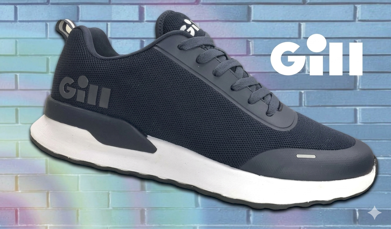 Black athletic sneaker with white sole and the brand name "Gill" on the side, set against a pastel brick wall background.