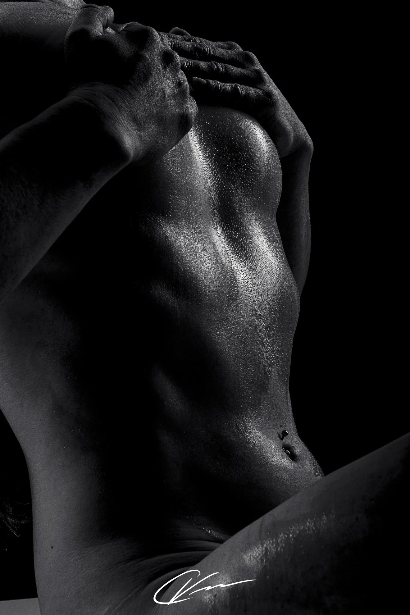 Close-up black and white photo of a woman's torso, hands resting on her head, water droplets on skin, signature at the bottom.