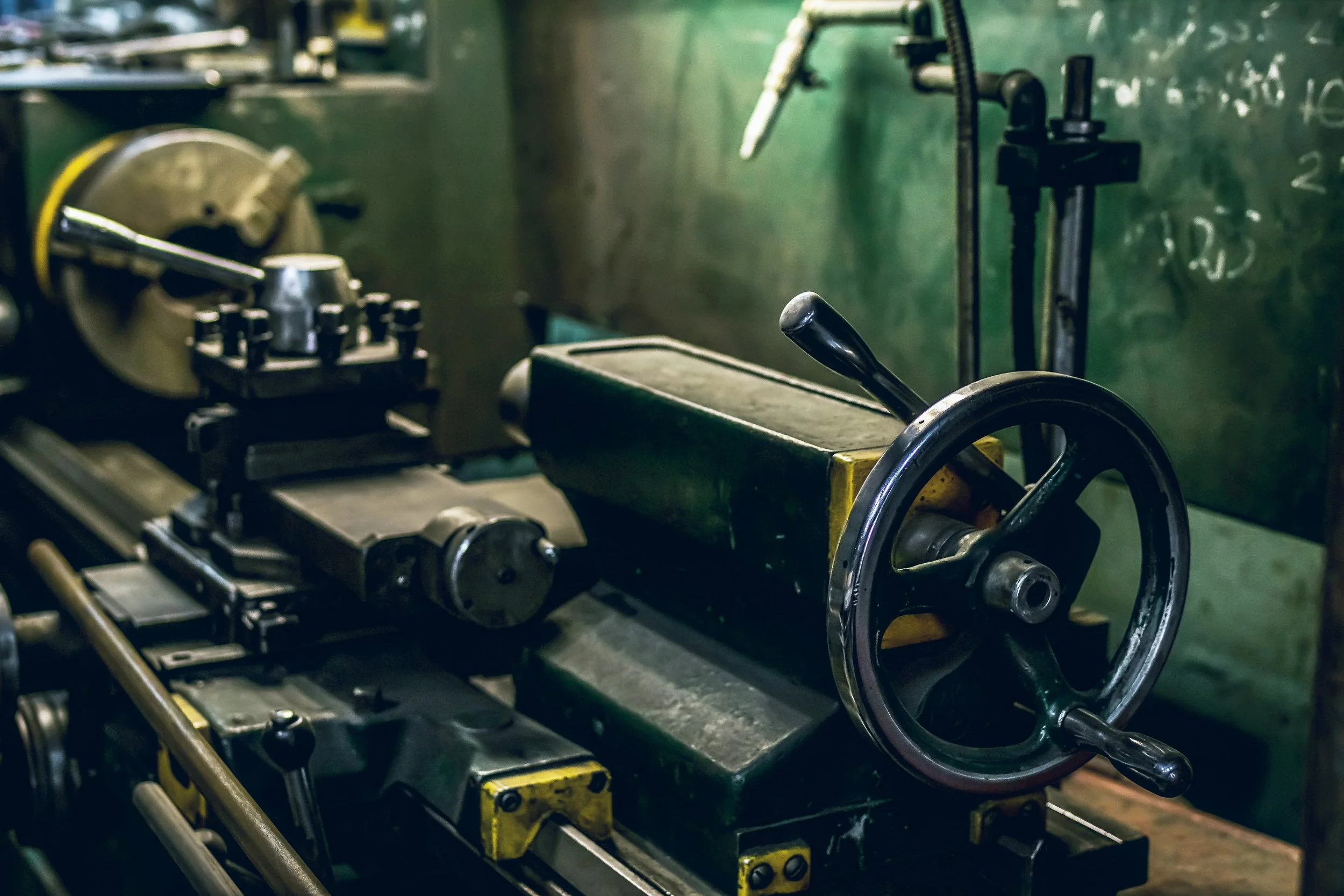 Close-up of an industrial lathe machine used for metalworking in a workshop.