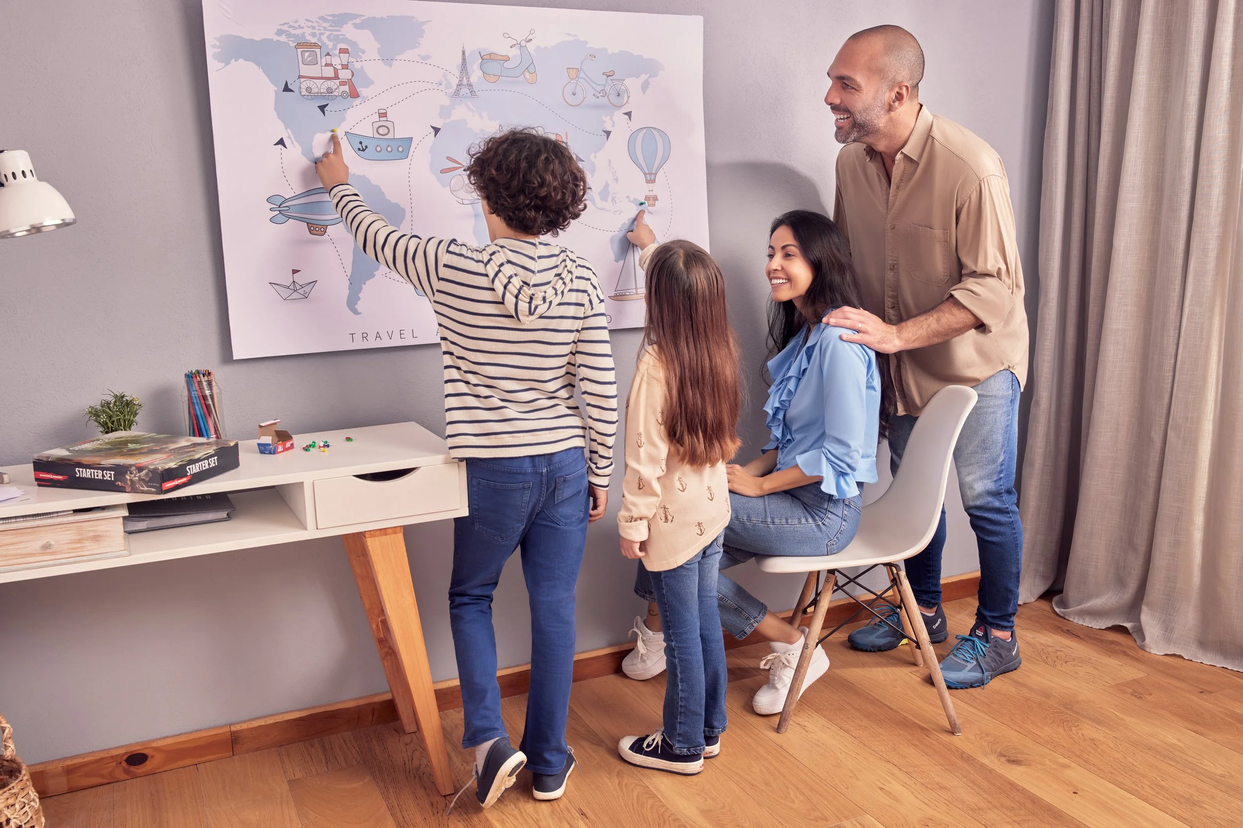 A smiling family of four explores a world map together at home, symbolizing international planning and future opportunities for EB5 families.