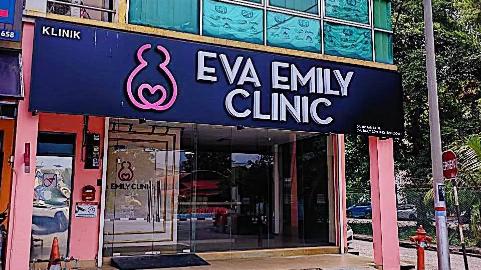 The front of the Eva Emily Clinic building with a large purple sign displaying a pink stylized bunny logo and the clinic's name in large white and purple letters.